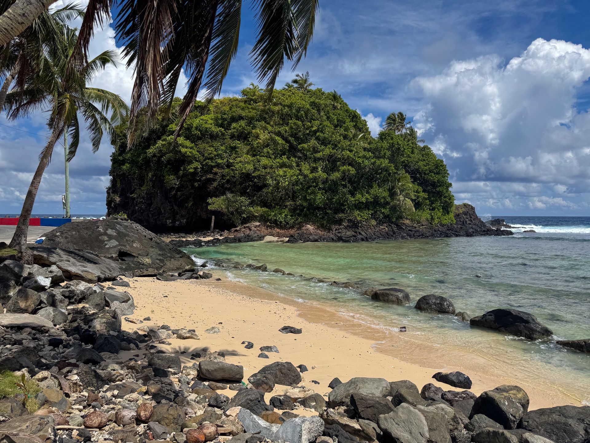 An island next to a sandy beach on the north coast of American Samoa
