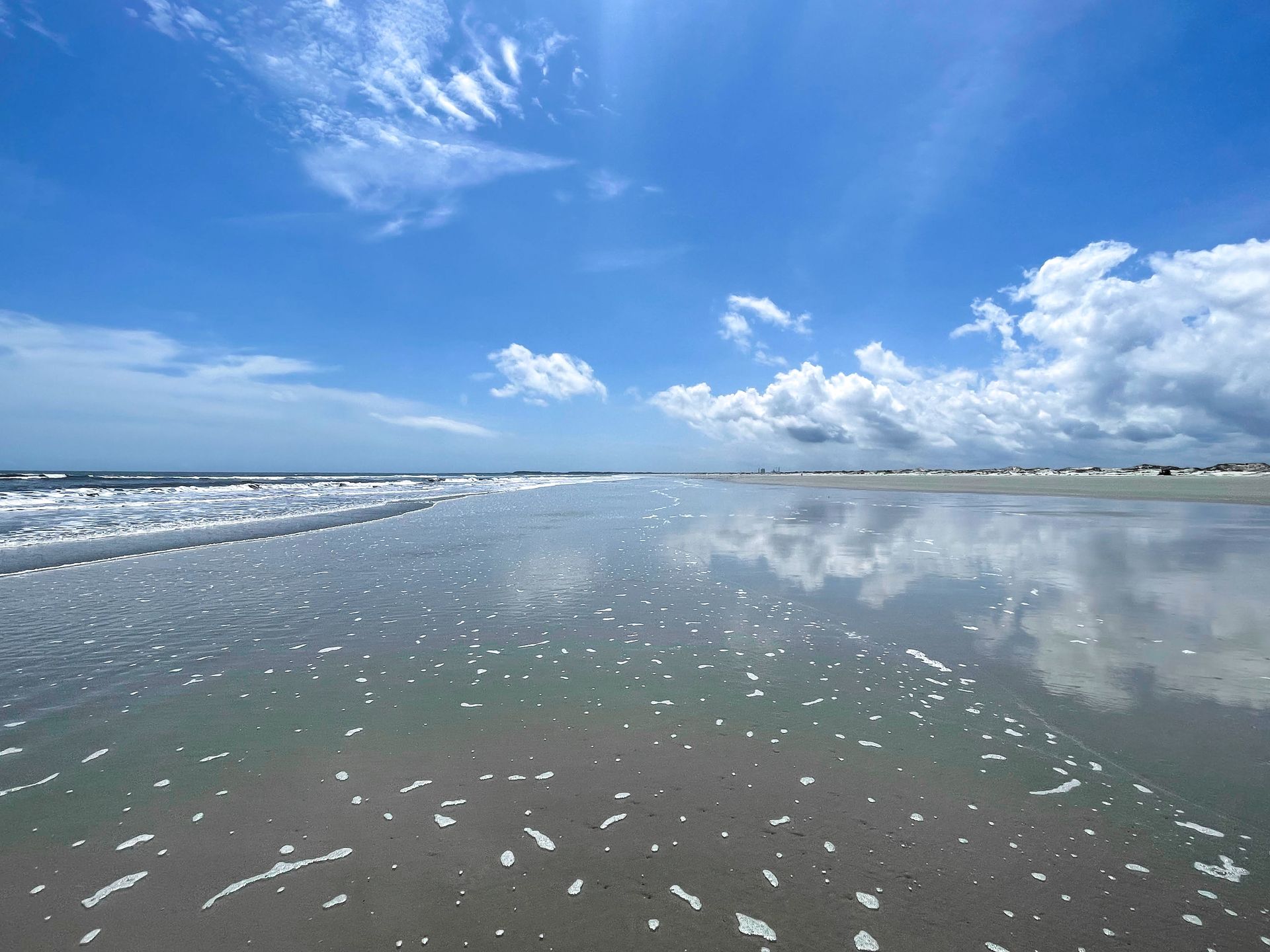 A white sand beach, and water reflecting the sky, on the coast of Cumberland Island