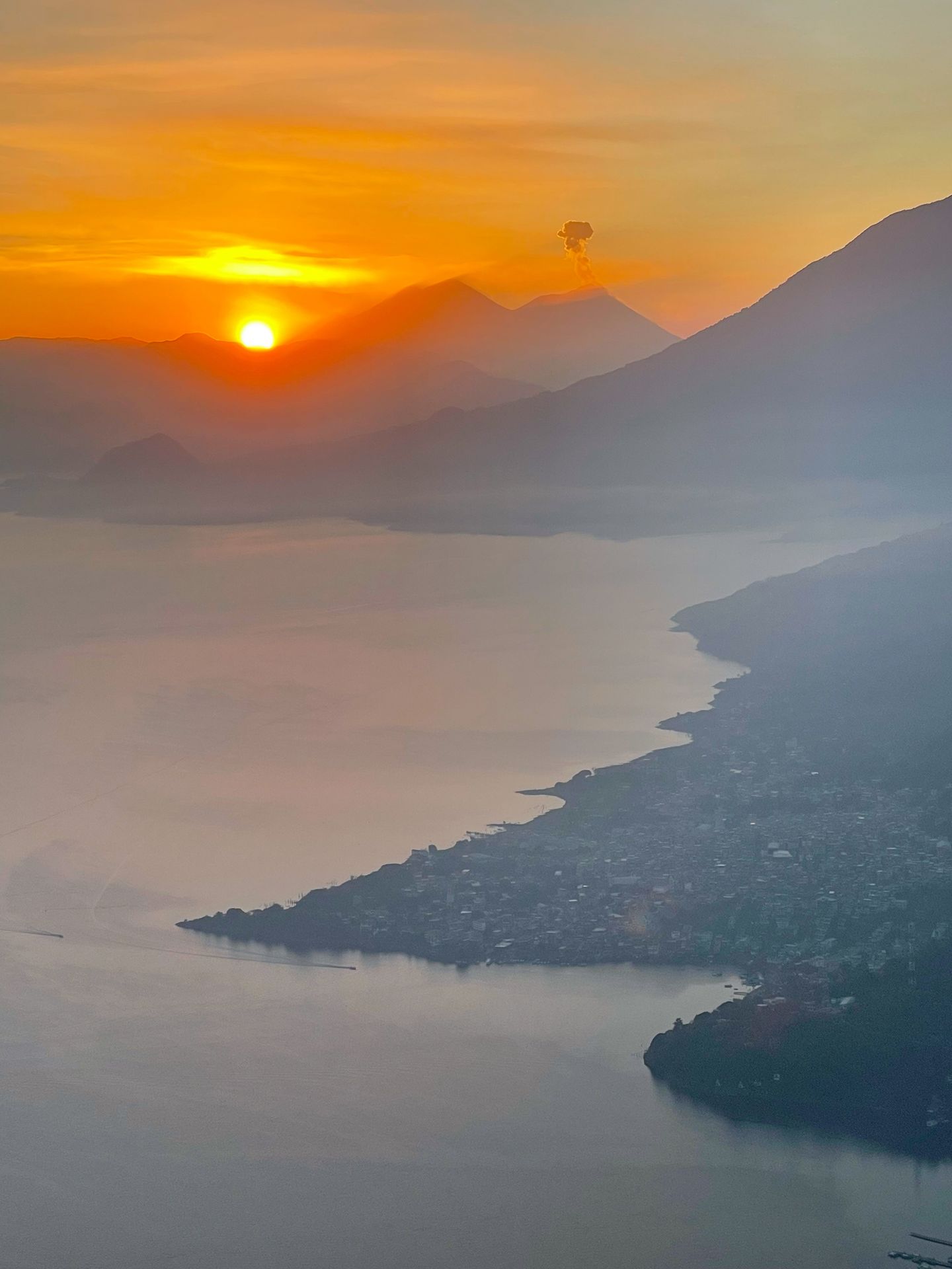 A view of Lake Atilian and volcanoes in the distance at sunrise, seen from Indian Nose