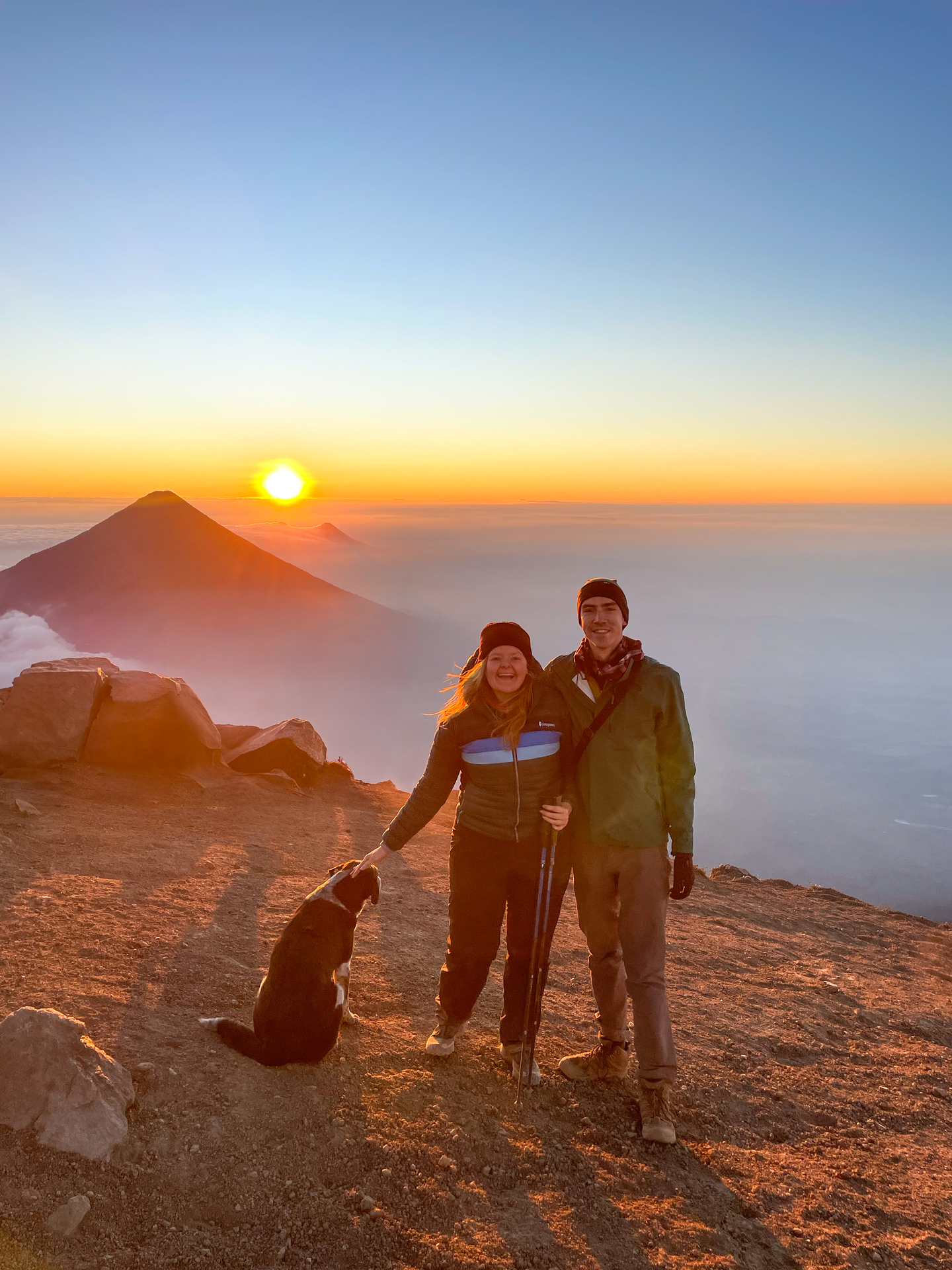 Lydia and Joe at the Acatenango Peak at sunrise, with a dog next to them