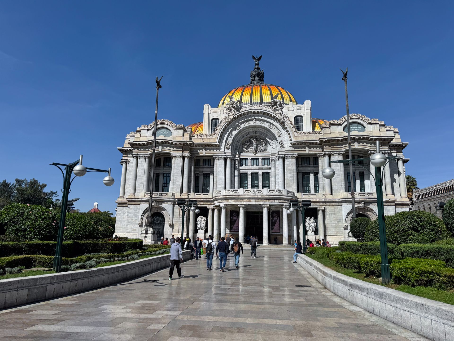 A white building with intricate stone detiails and a yellow-domed roof.