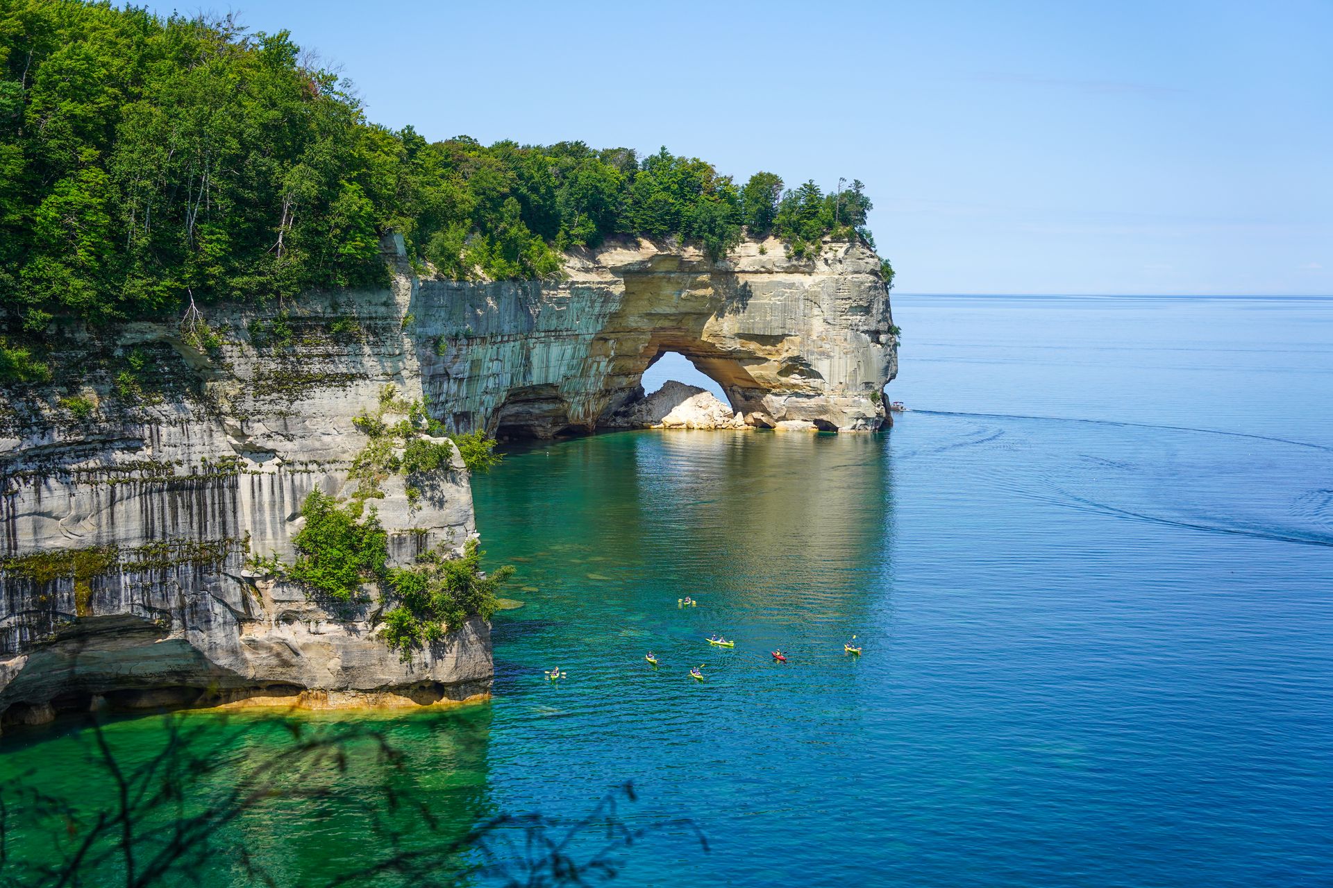 A view of Lover's Leap Arch seen from the trail. There are kayaks in the water below.
