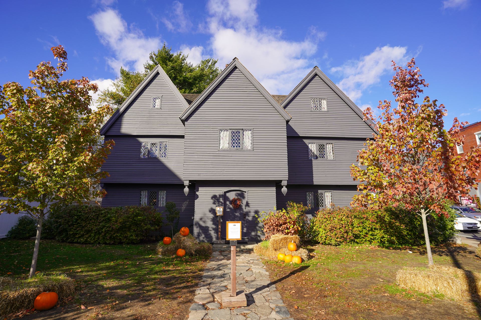 A gray house with some pumpkins out front