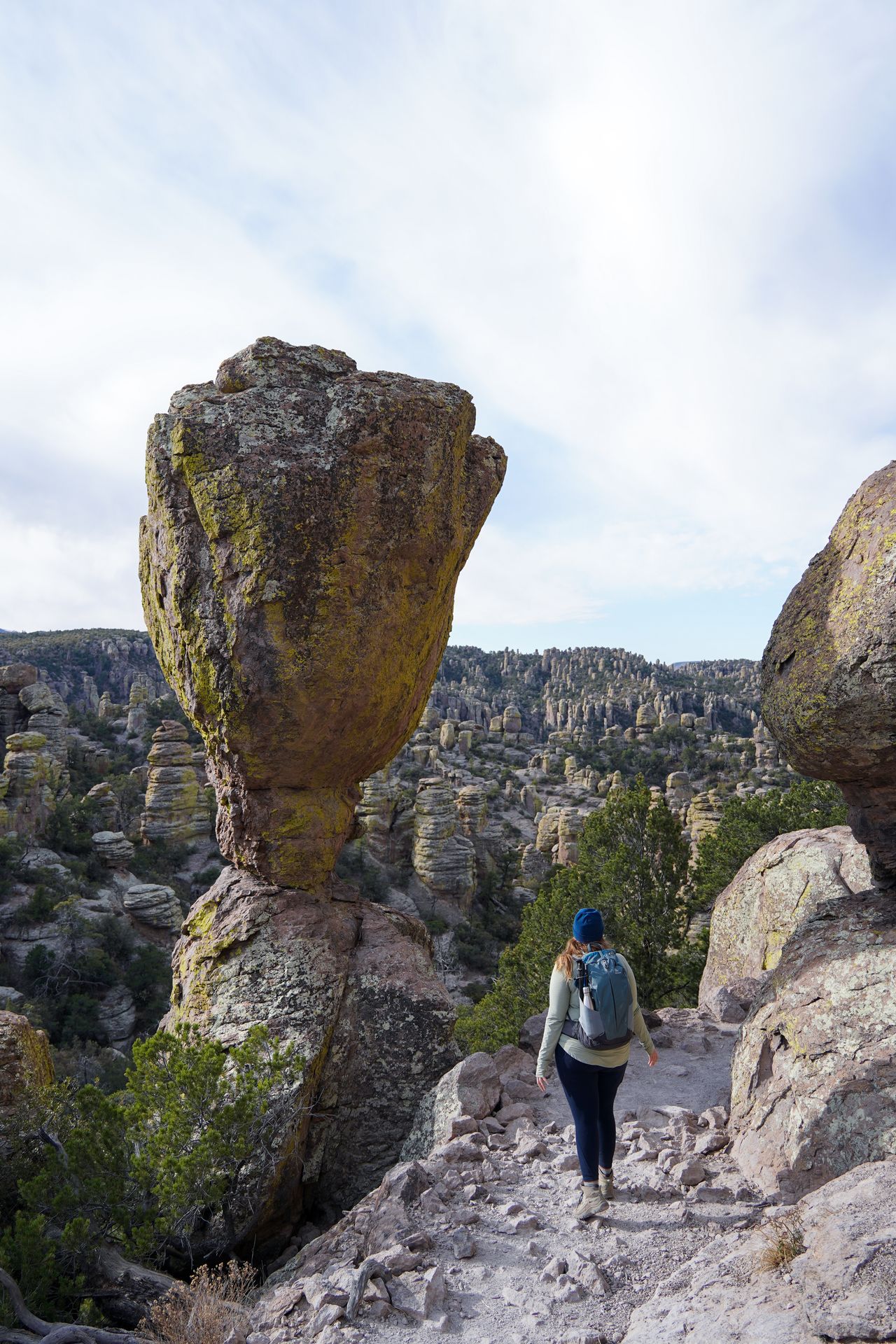Lydia standing next to a huge balanced rock on the Echo Canyon trail