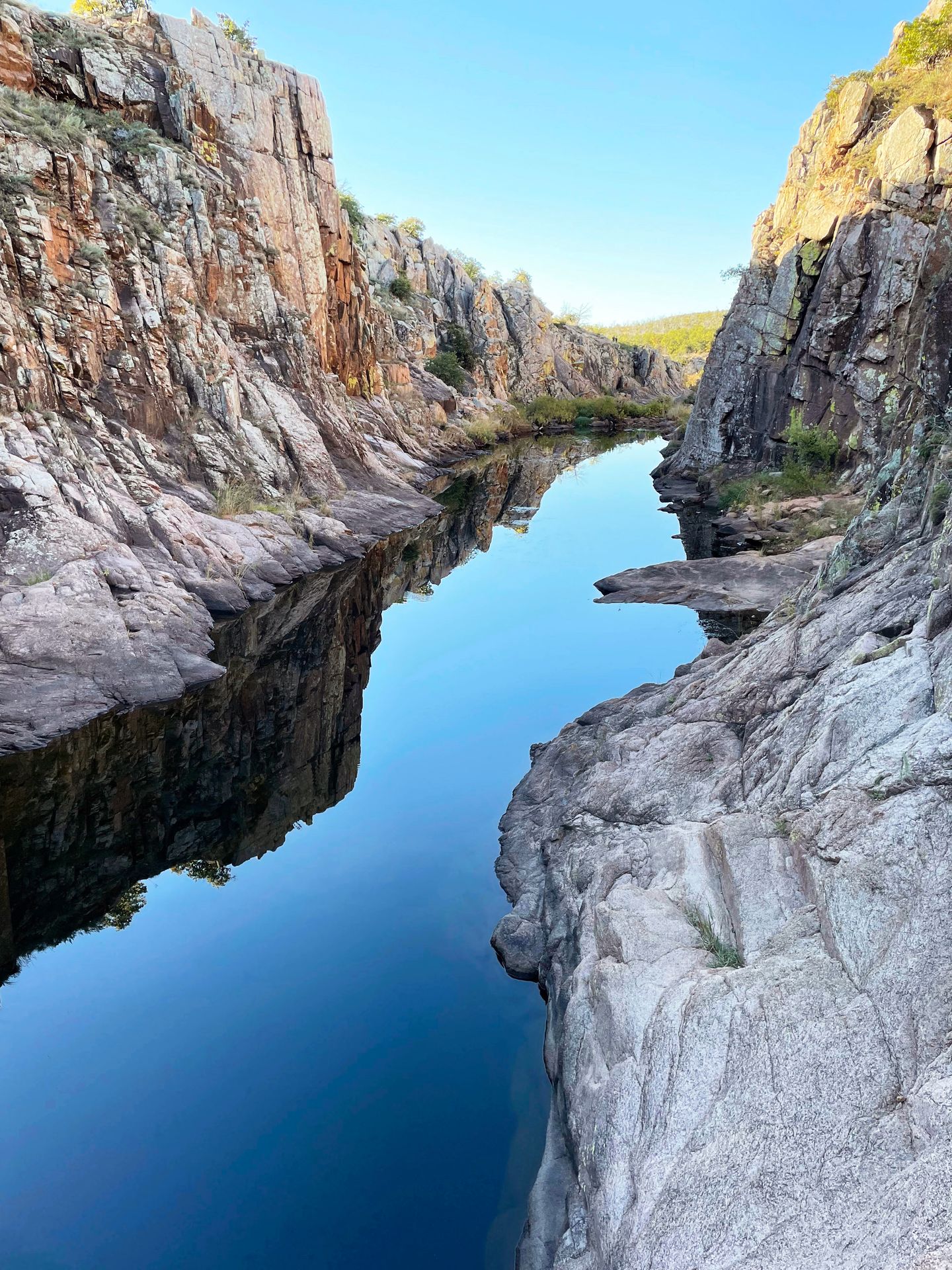 A river with rock walls towering up on both sides on the Forty Foot Hole trail in the Wichita Mountains, Oklahoma