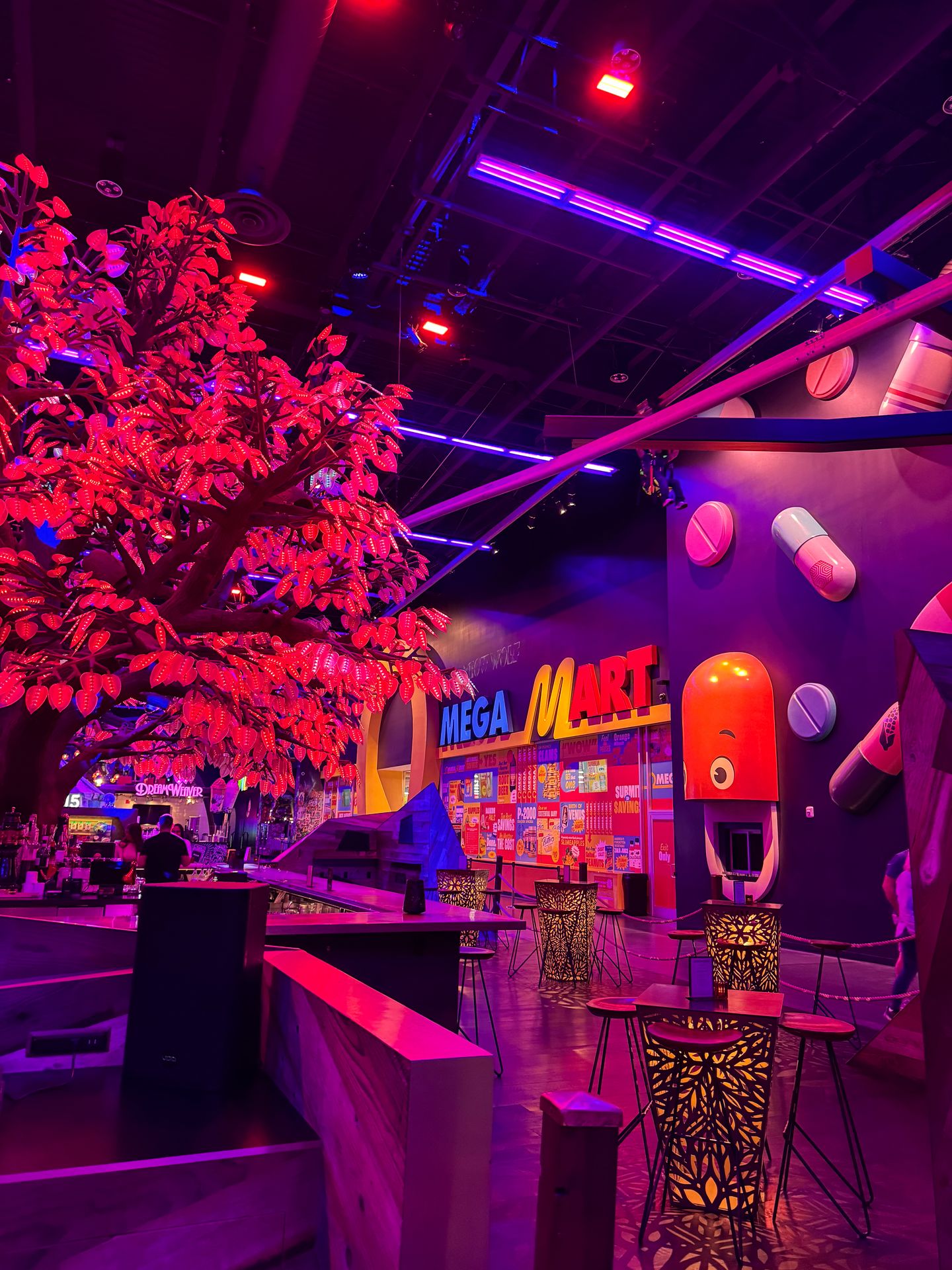 The entrance of Omega Mart inside of AREA15. The walls glow purple and there is a pink tree indoors