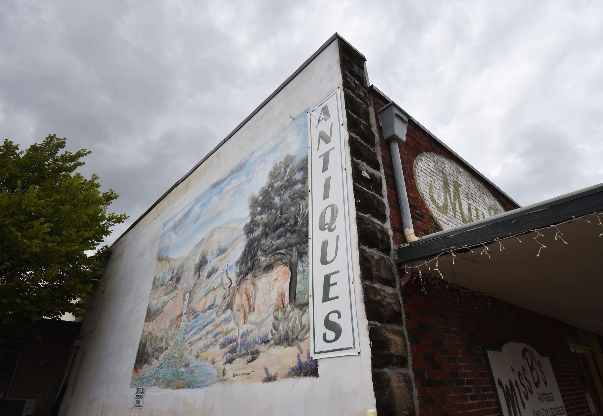 A mural and the word "Antiques" on the side of a building in Weatherford.