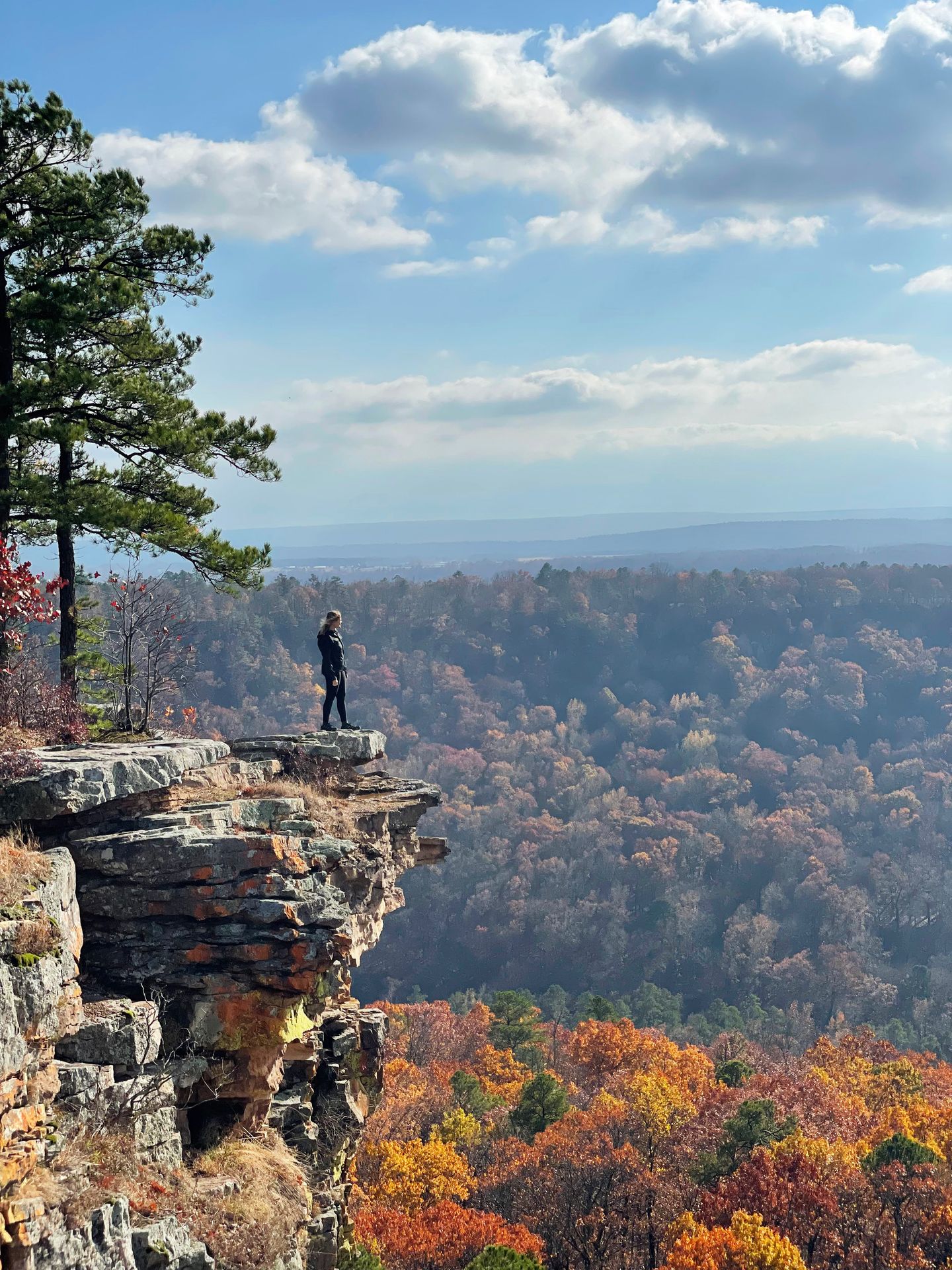 Lydia standing on a rocky ledge with a valley below at the CCC Overlook.