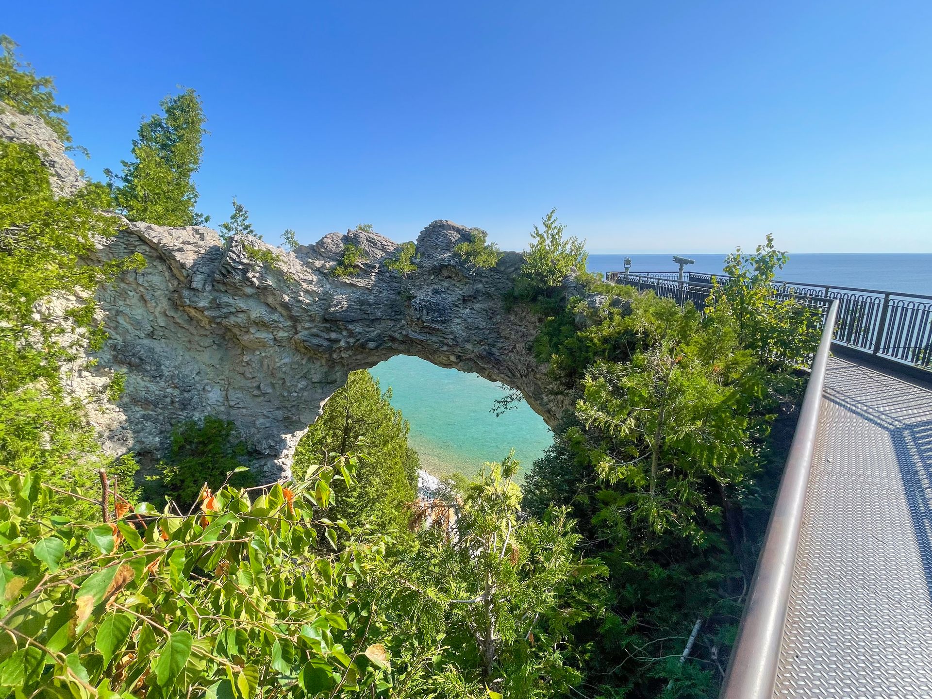 Looking at Arch Rock. A path with a railing leads closer to the right side of the arch.