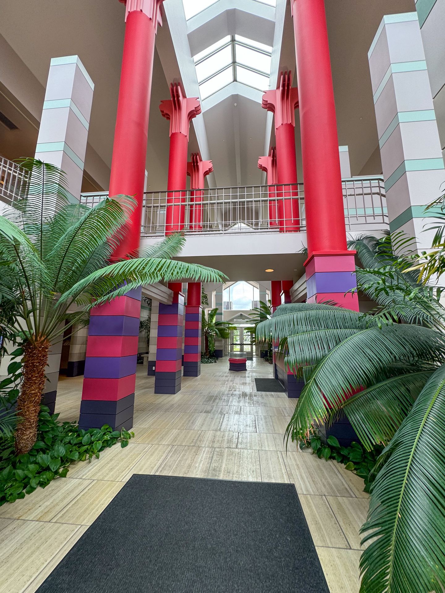 The lobby of the Cedar Rapids Museum of Art with colorful columns and large green plants.