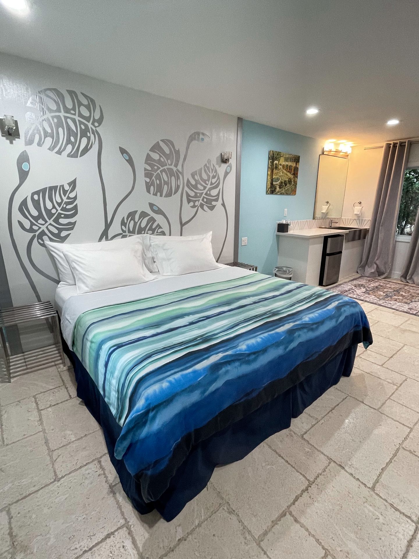 A bed with blue and green strips inside the Retreat at Crystal Manatee Hotel.