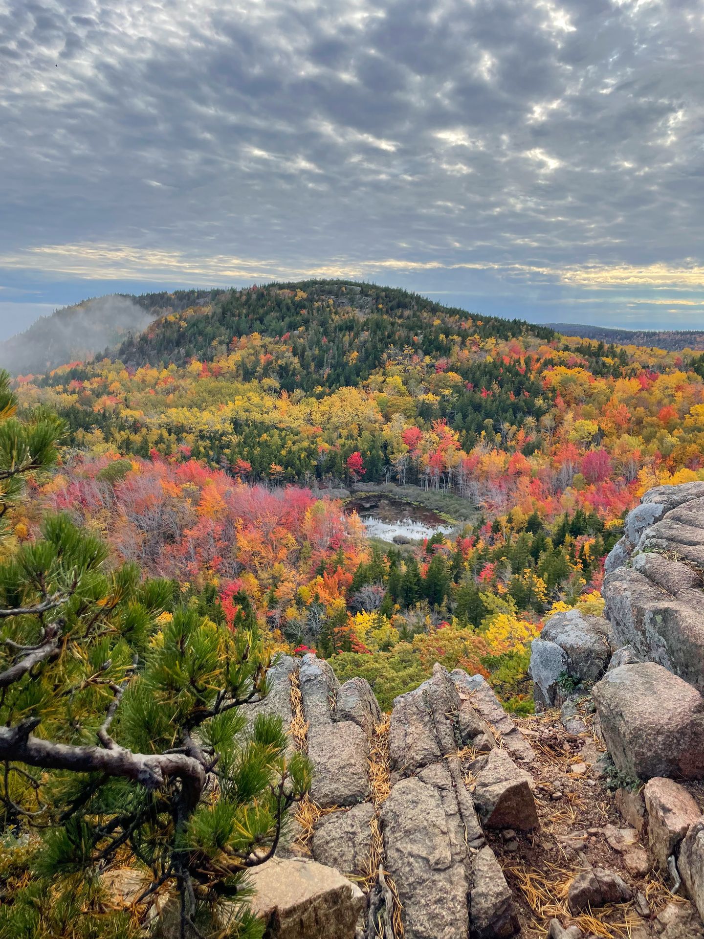 Looking down at a small lake surrounde by fall foliage from the Beehive Trail