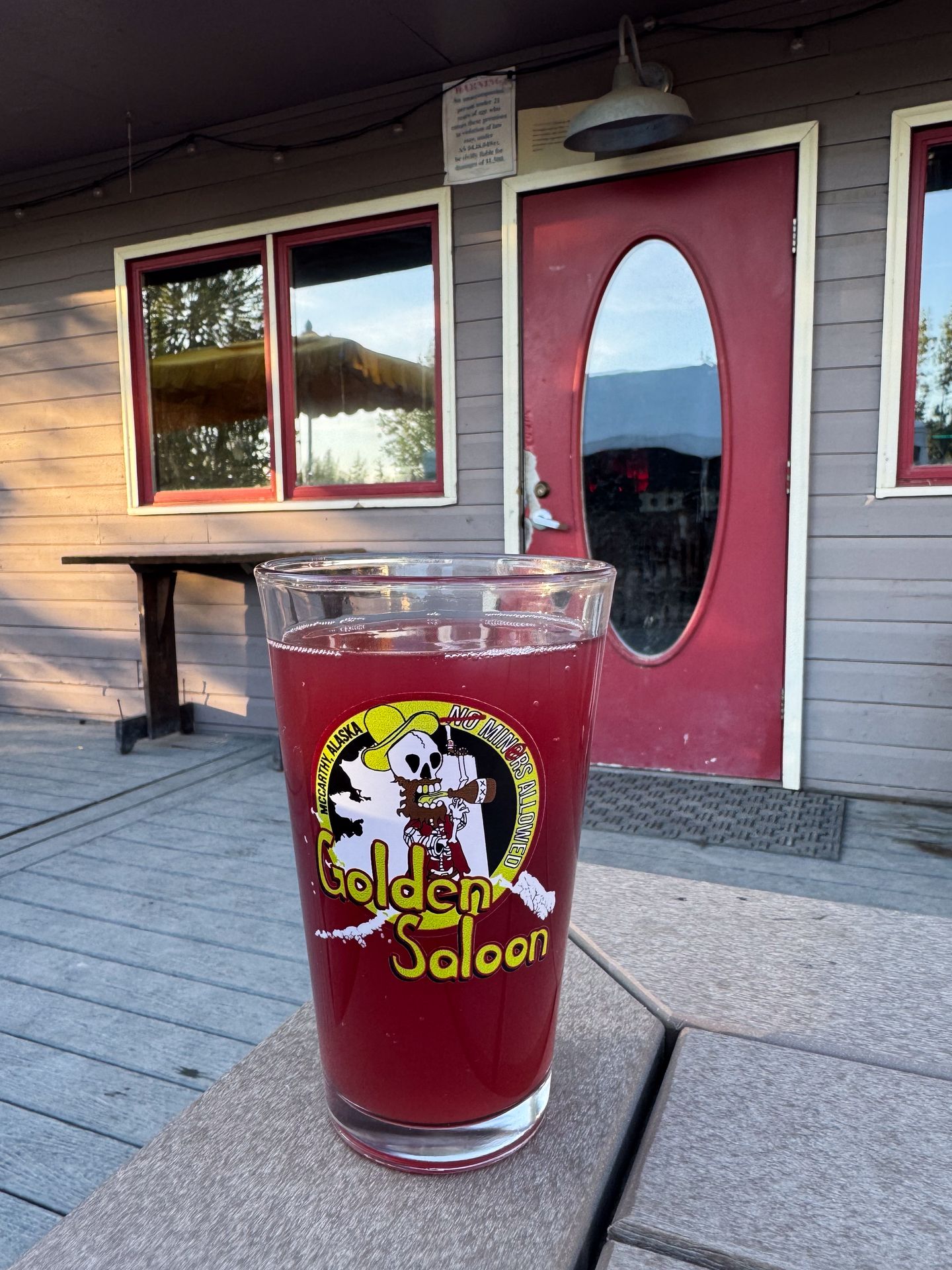 A red beer sitting on a table on the patio of The Golden Saloon
