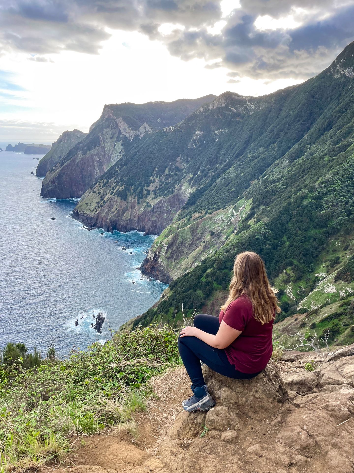 Lydia sitting and looking at the view of the water and coast from the Boca do Risco Trail