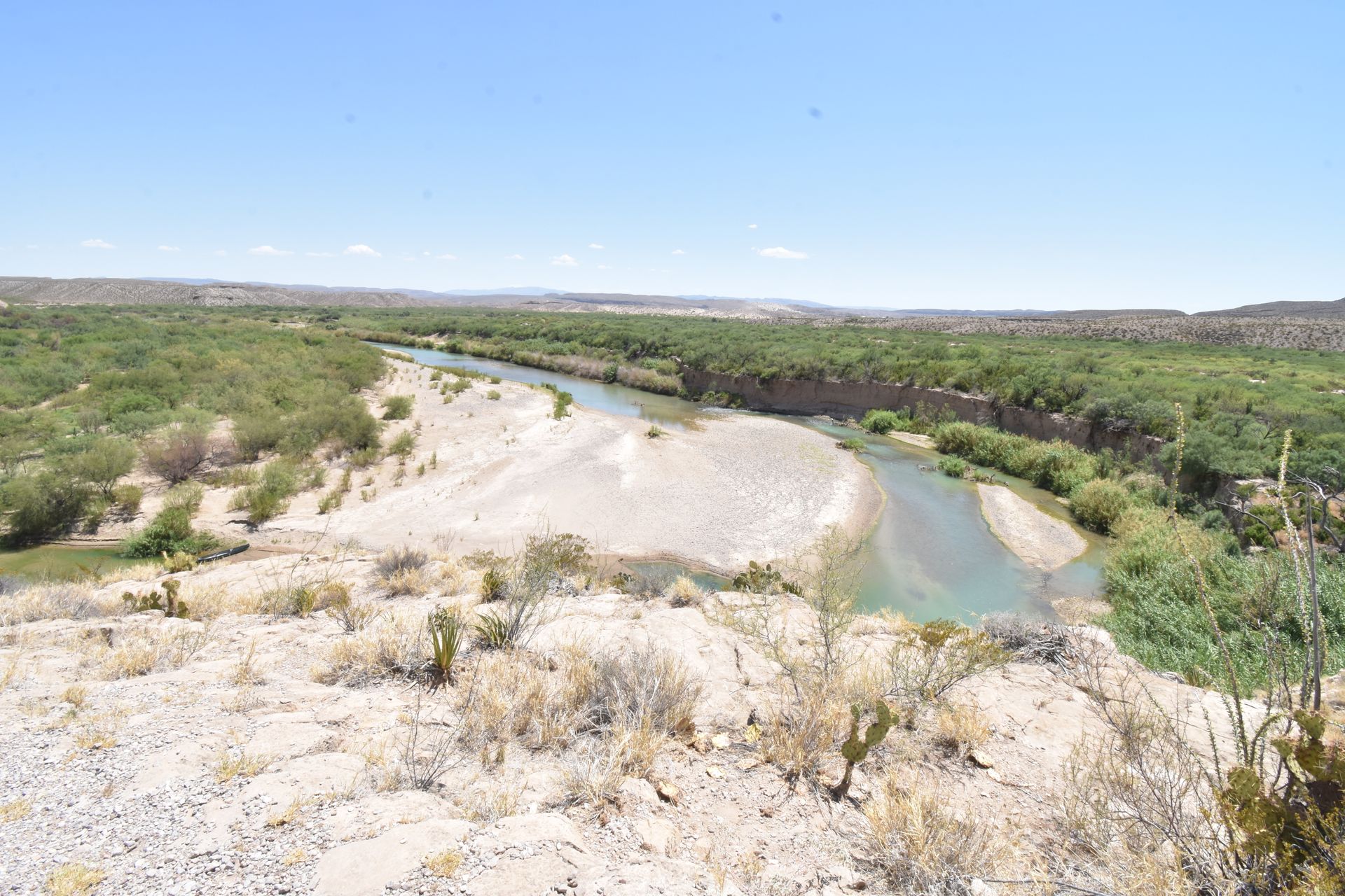 Looking down at the Rio Grande River next to a sandy beach. The beach is in Mexico.