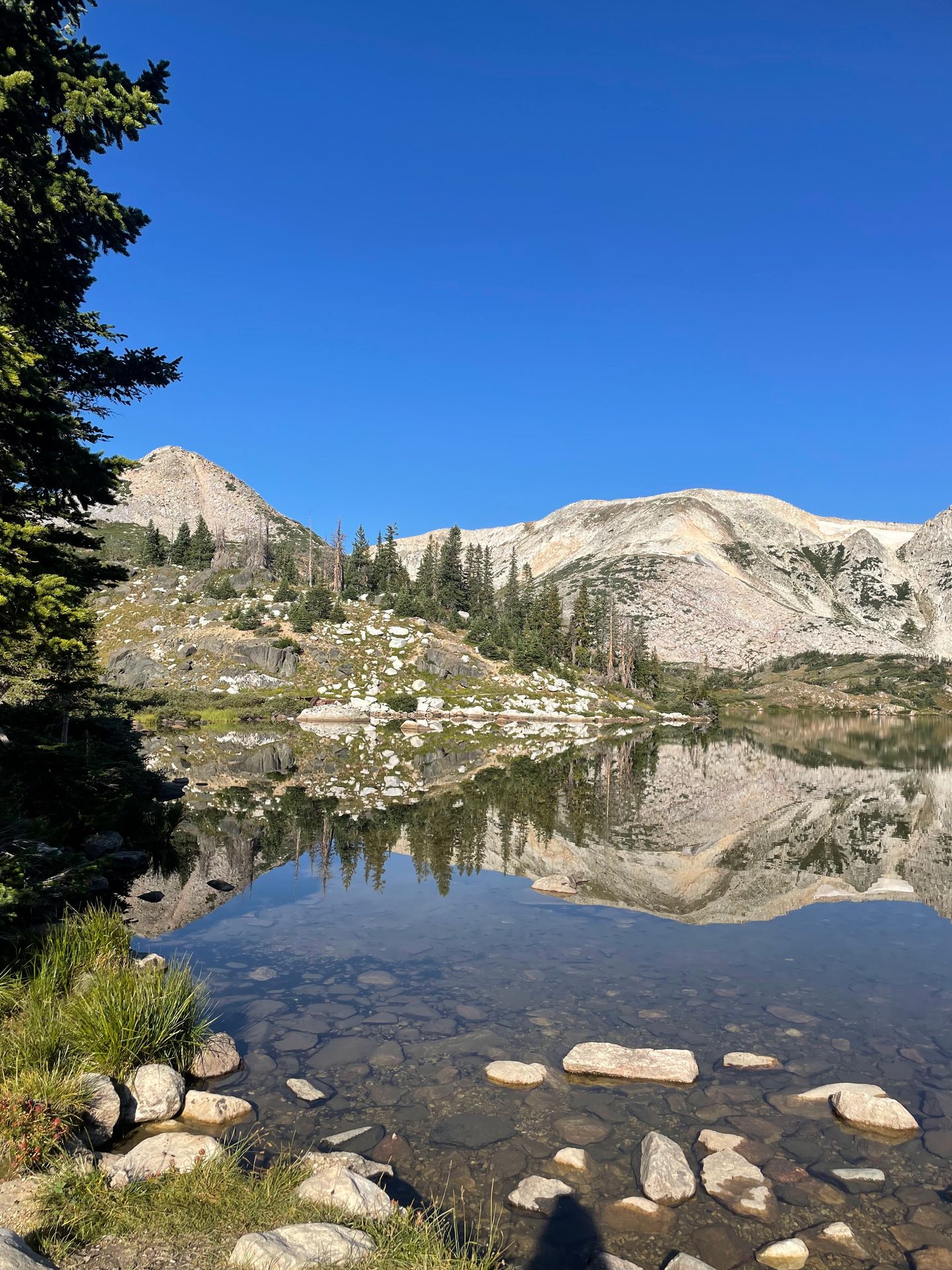 A lake reflecting a mountain in Medicine Bow National Forest