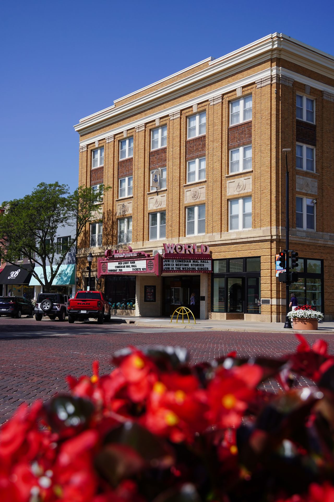Looking across the street at The World Theater with red flowers in the foreground