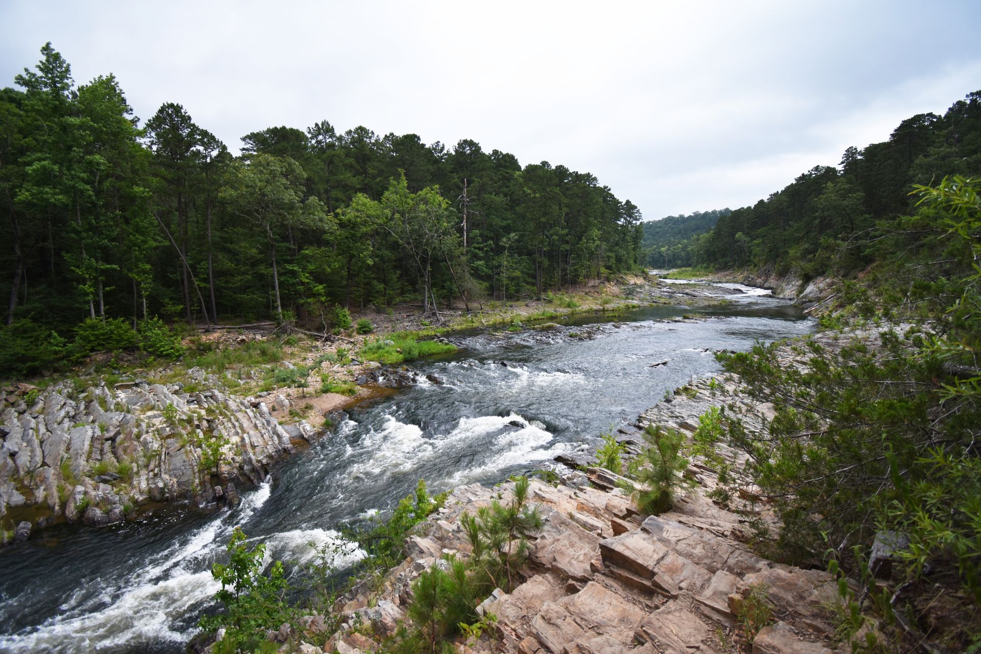 A river surrounded by rocks and trees in Beaver's Bend State Park.