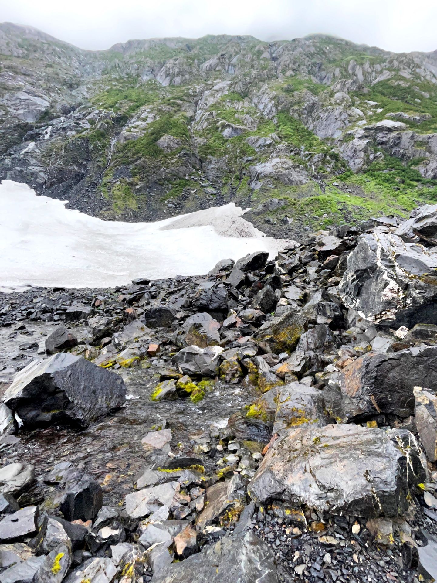 Gray rocks with a small glacier in the distance.