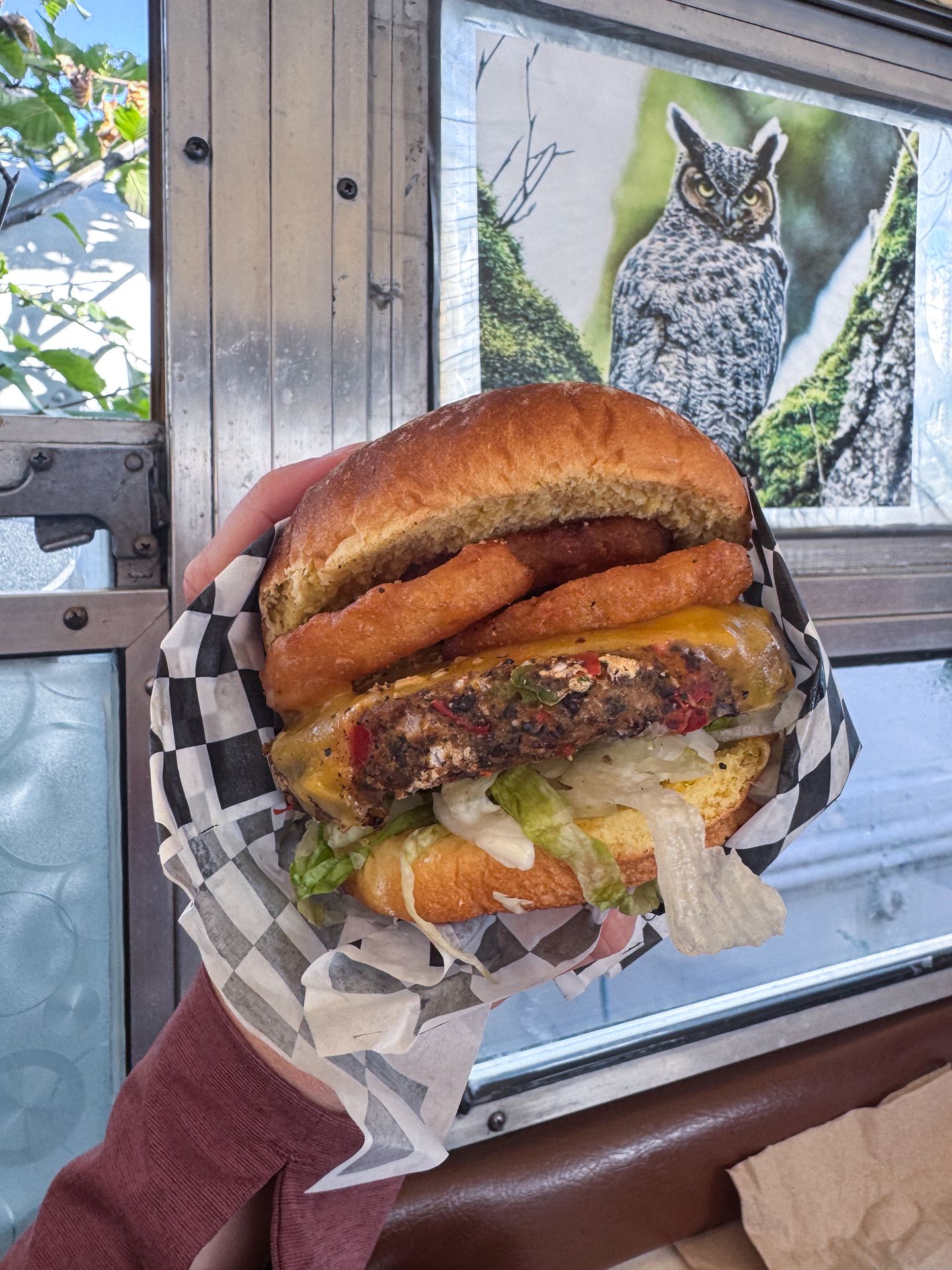 Holding up a veggie burger with onion rings on it from Red's Burgers