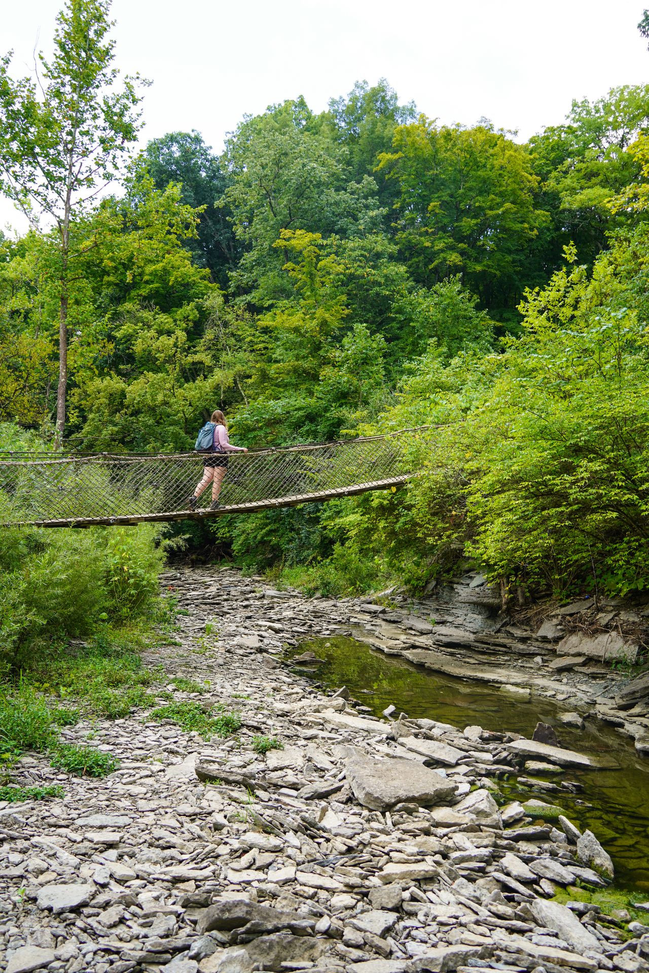 Lydia walking across a suspension bridge while hiking in Caesar Creek State Park