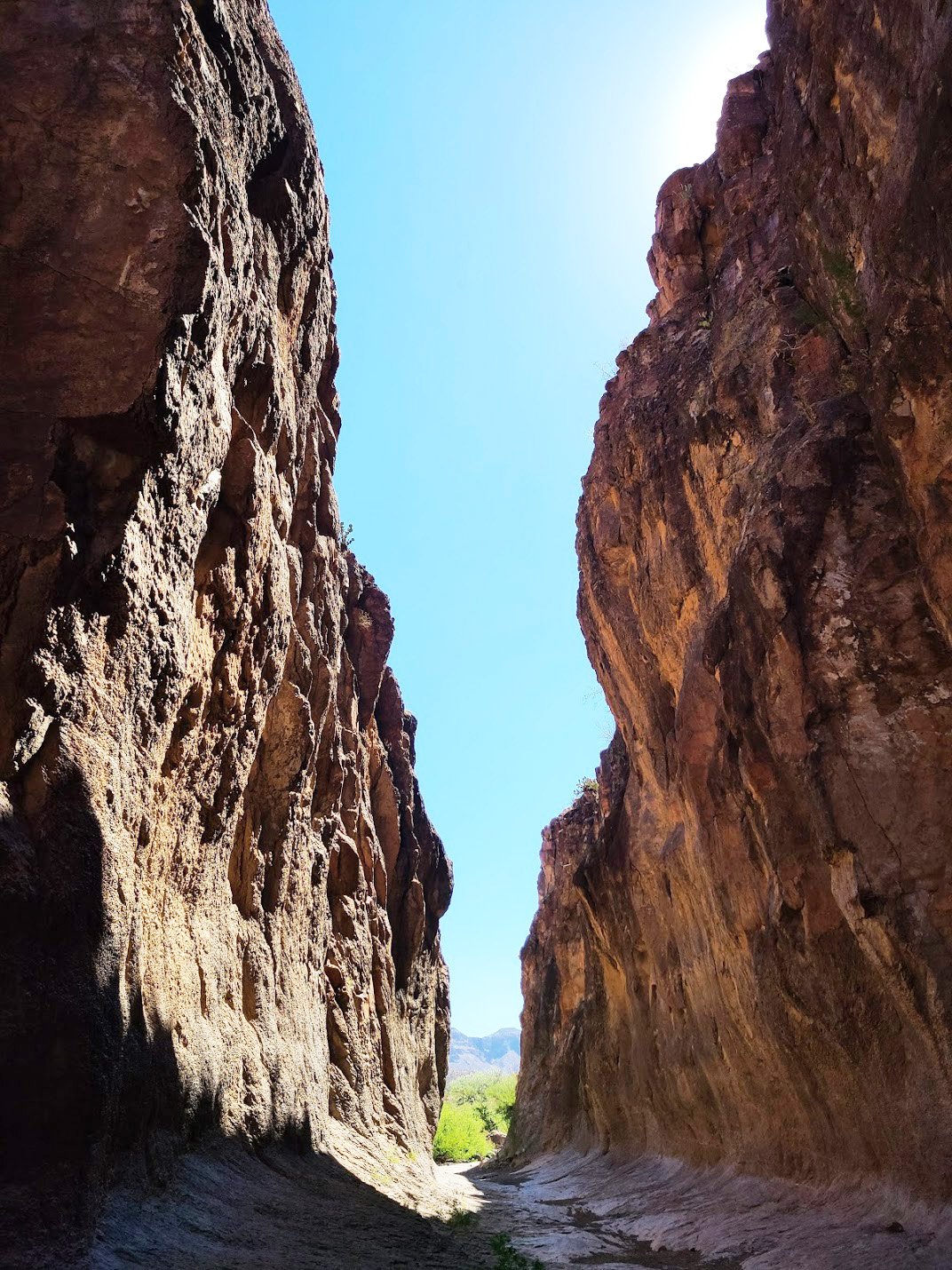 A view inside the slot canyon of towering canyon walls on either side.