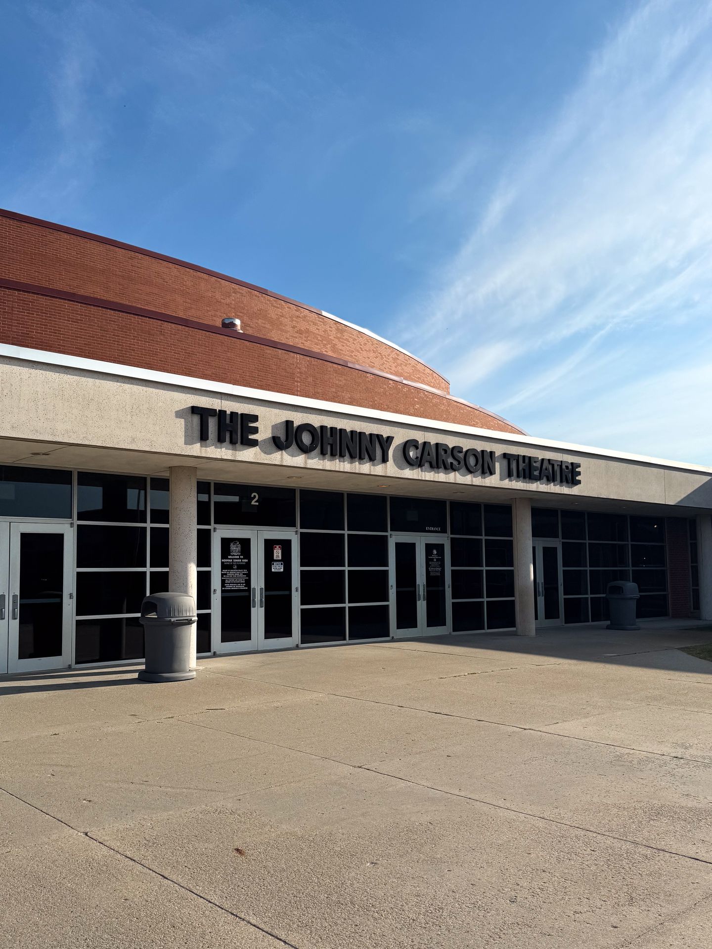The exterior of a brick building labeled 'The Johnny Carson Theatre'