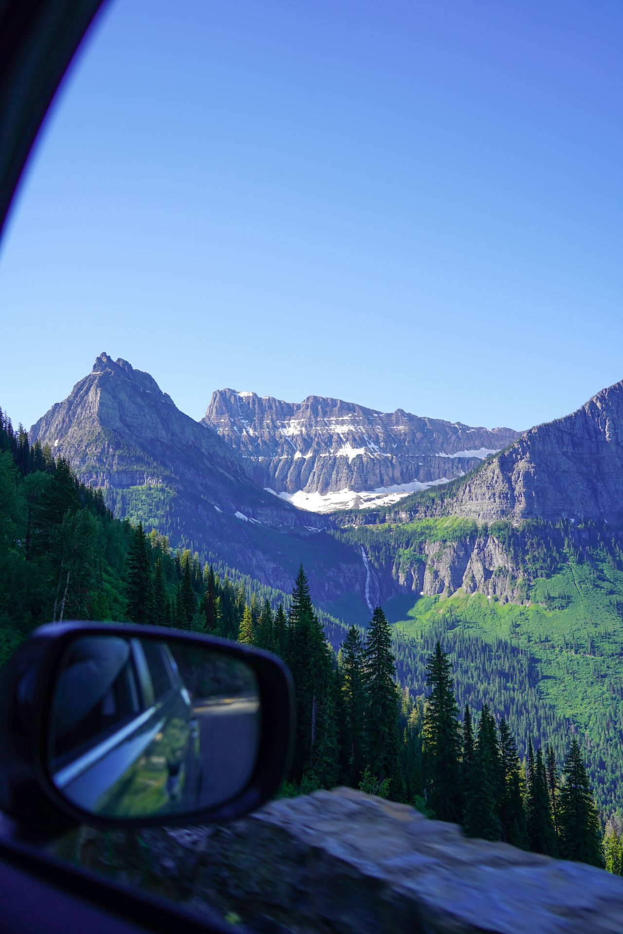Looking out the window at mountains while driving the Going-to-the-Sun road