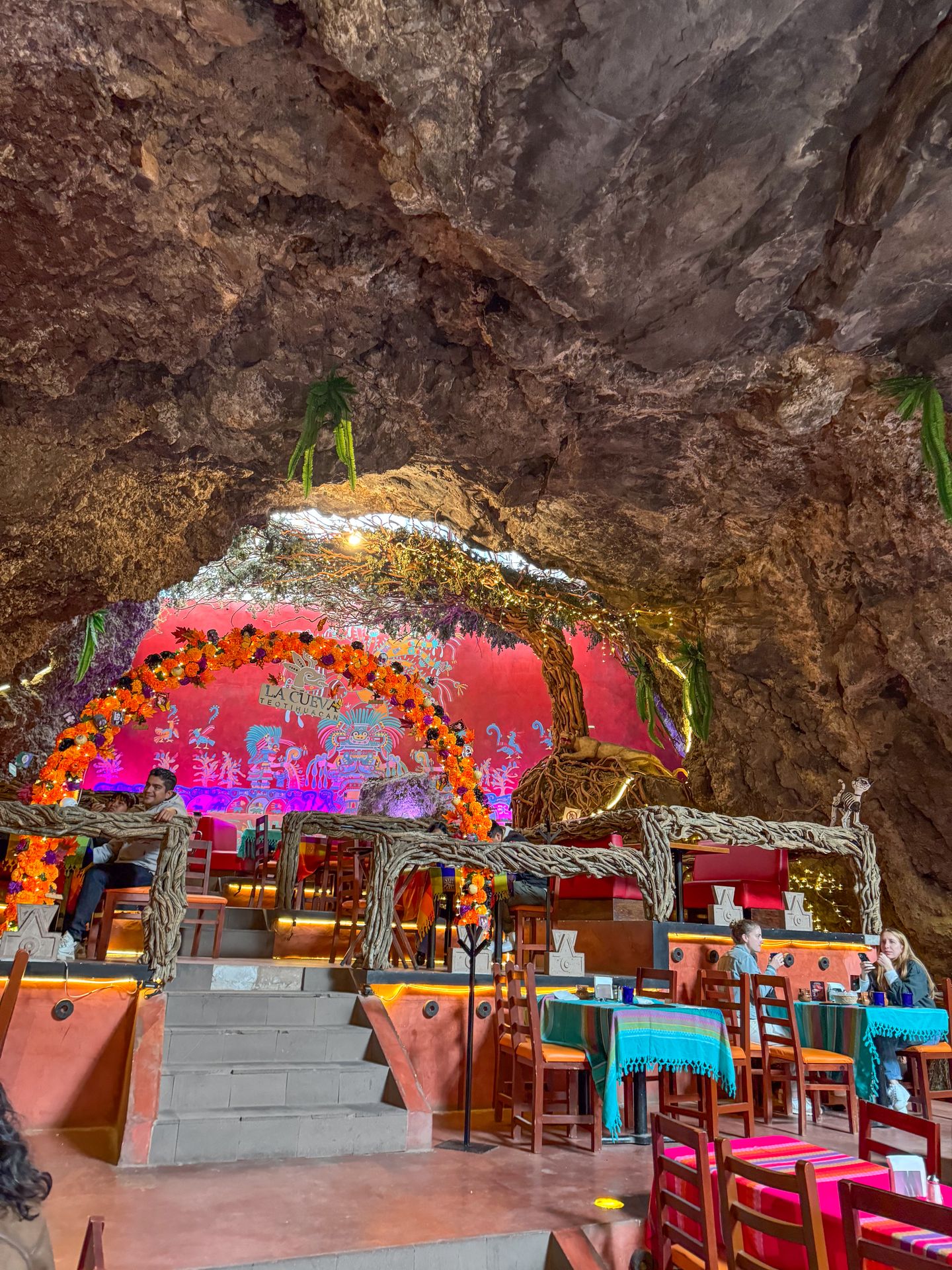 Colorful tables and a stage under the roof of a cave