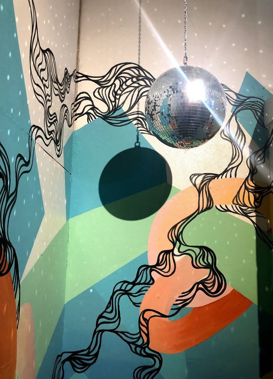 An abstact mural and disco balls at Celestial Brewery.