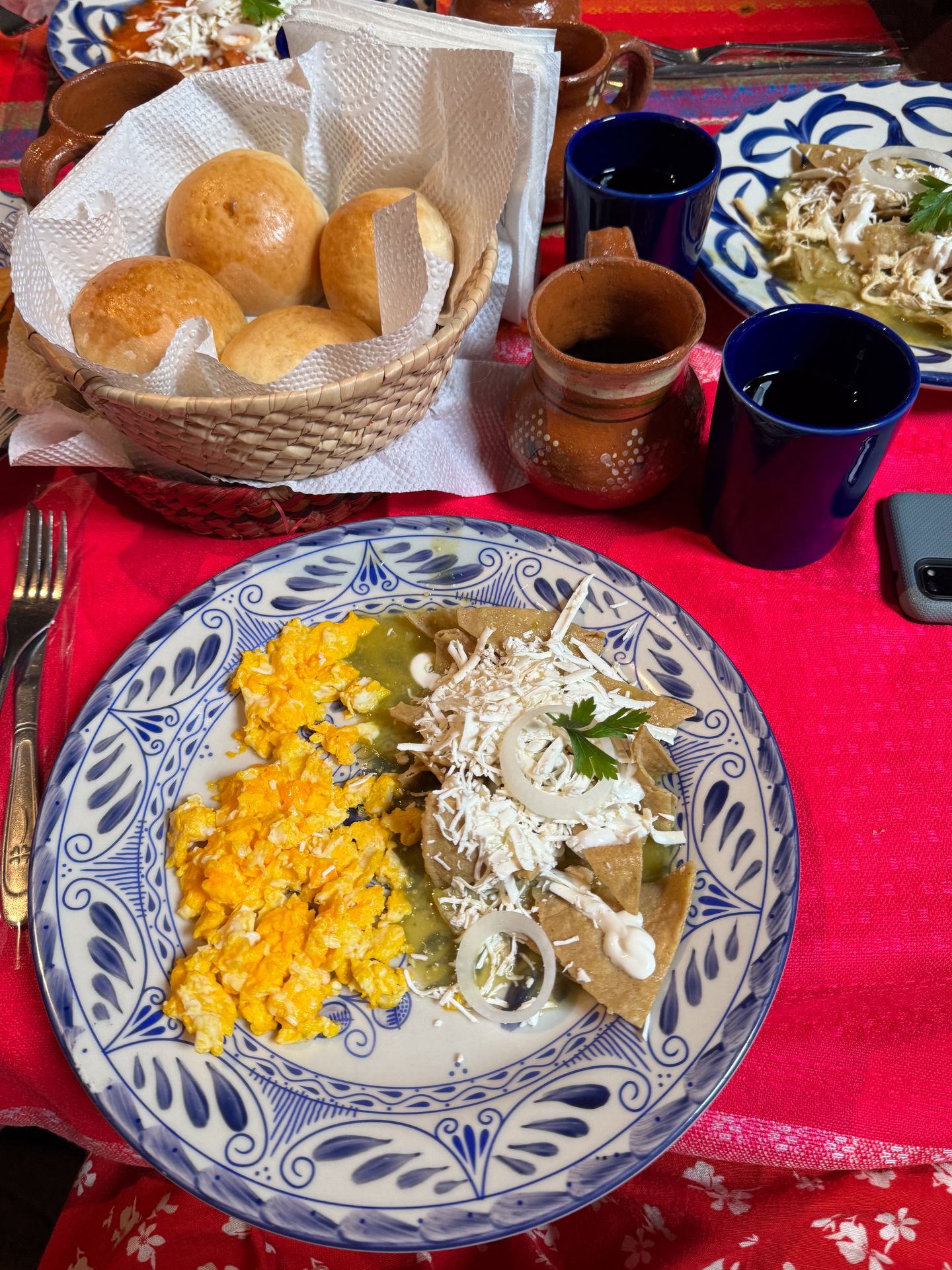 A plate of chilaquiles with scrambled eggs and cheese