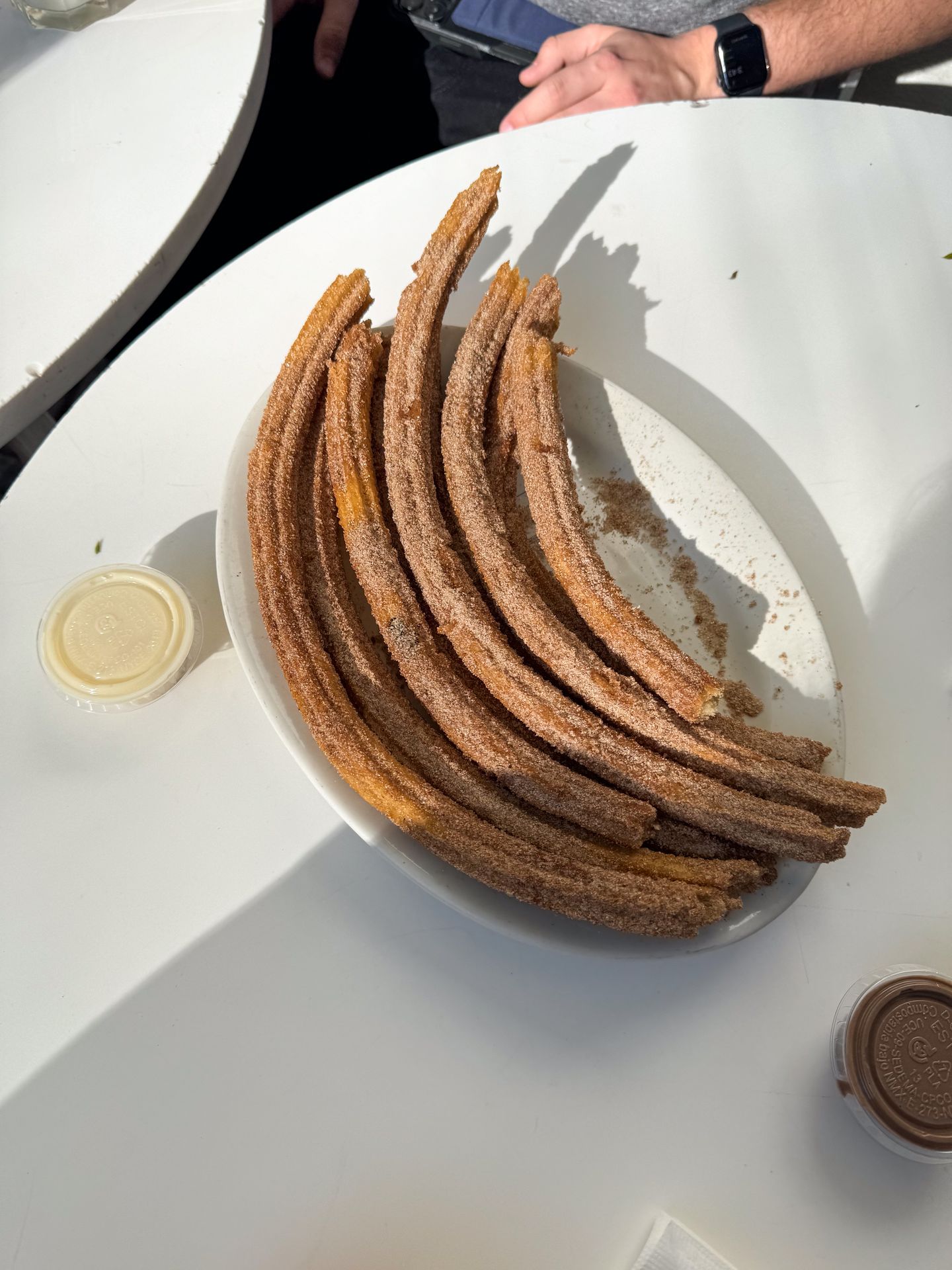 A plate of several churros on a white table