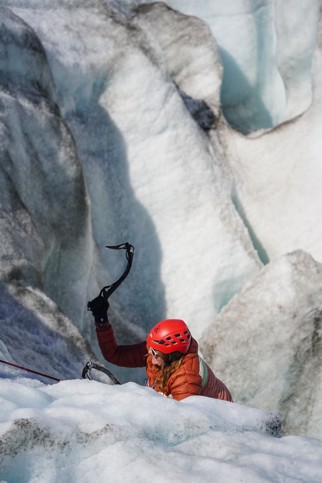 Lydia emerging out from the glacier moulin while ice climbing on the Root Glacier