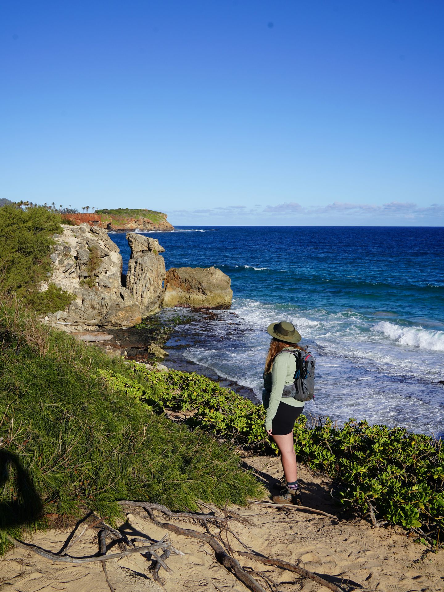 Lydia on a coastal trail looking out to an interesting rock formation along the coast