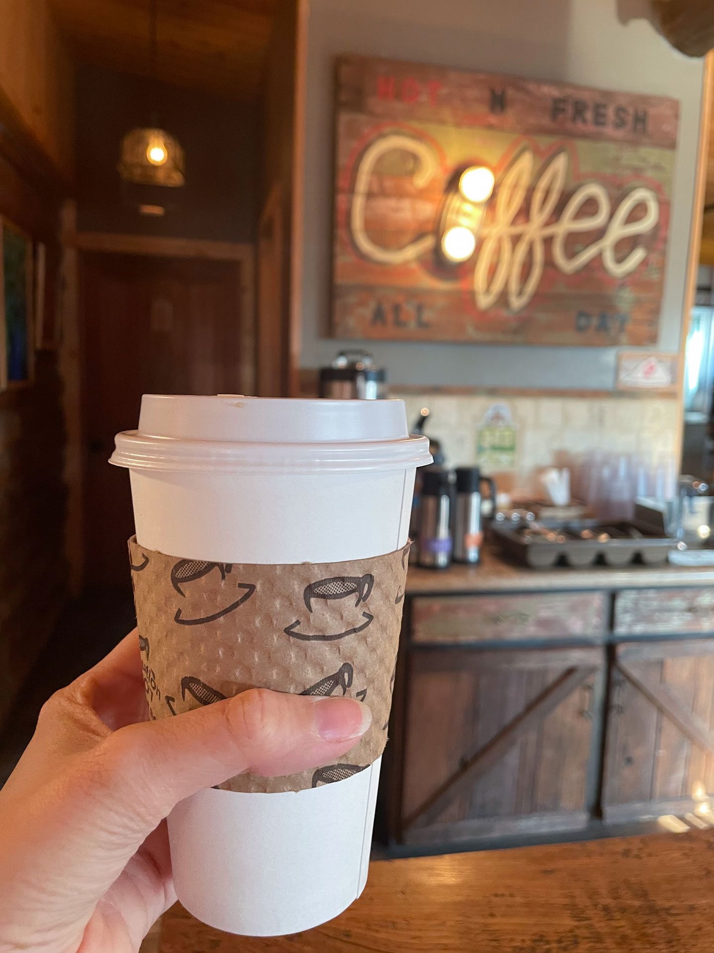 Holding up a coffee in the Stanley Baking Company & Café.