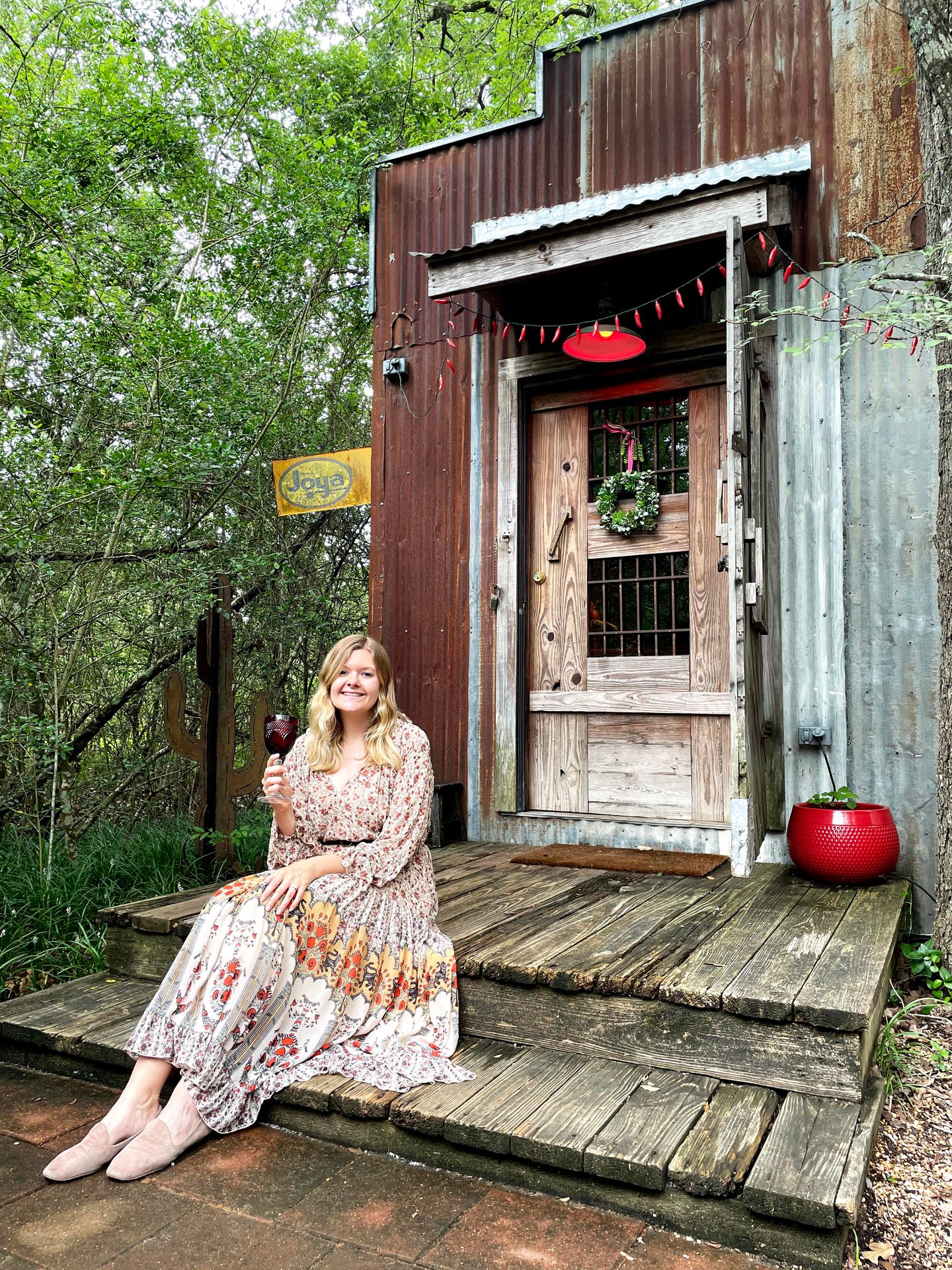 Lydia sitting on the porch with a glass of wine at the 7f Lodge.