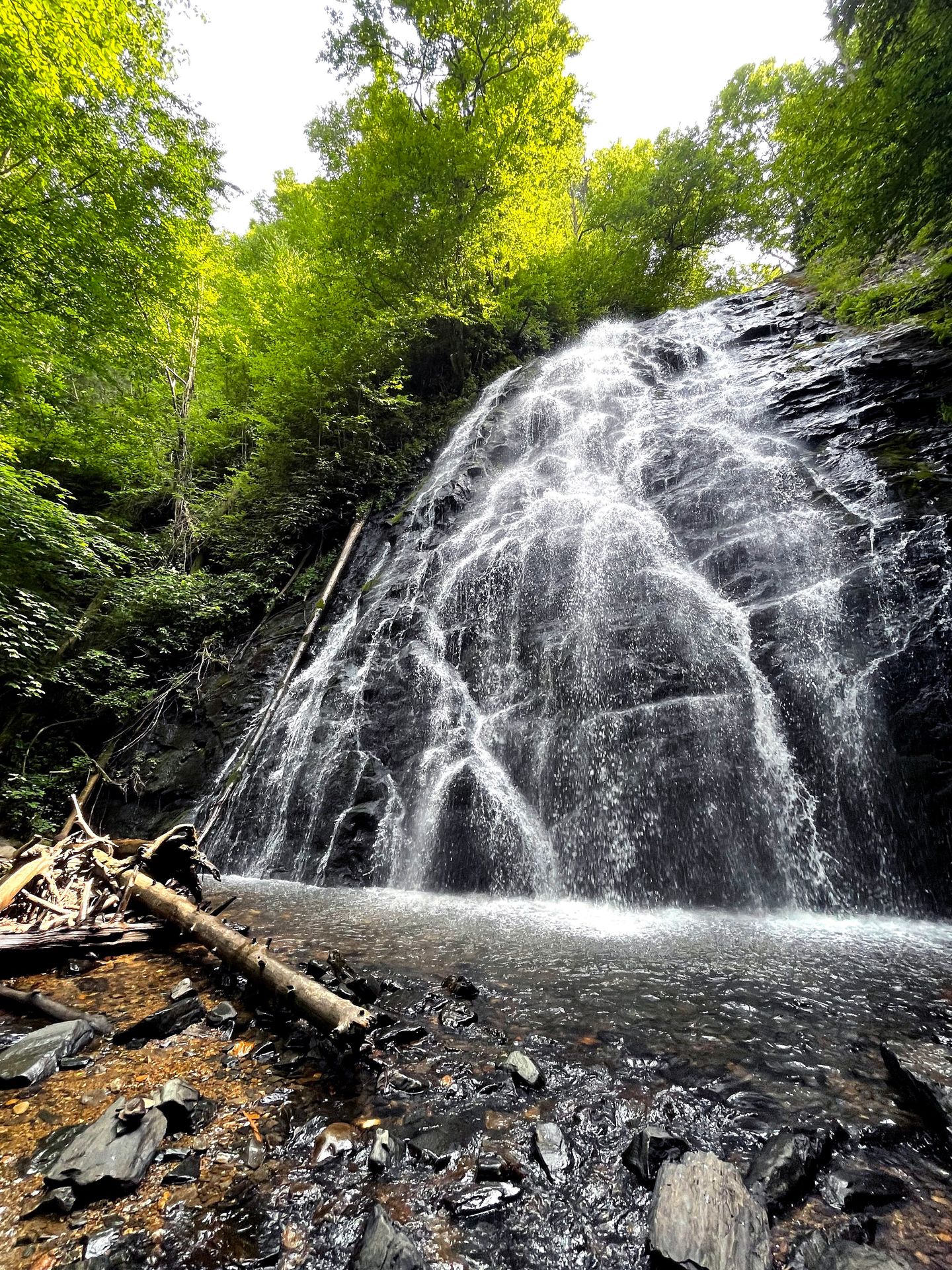 A tall waterfall flowing down a slab of rock.