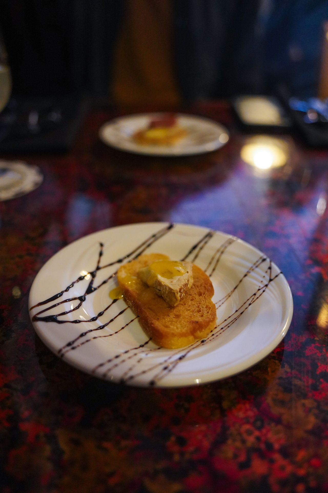 A crostini on a plate dressed with balsamic stripes at the Salmon & Bear