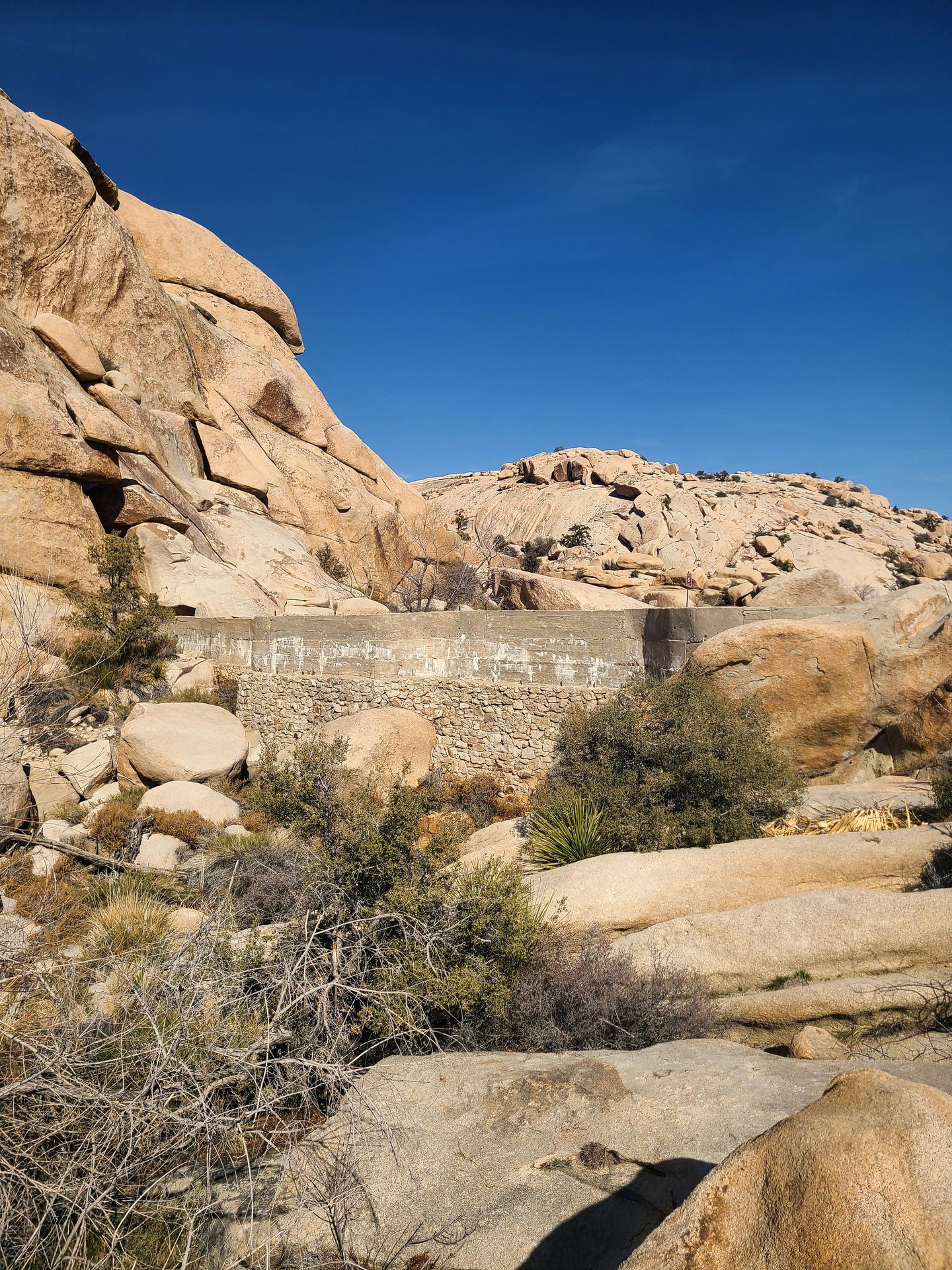 A dam that blends into an area of tan boulders.