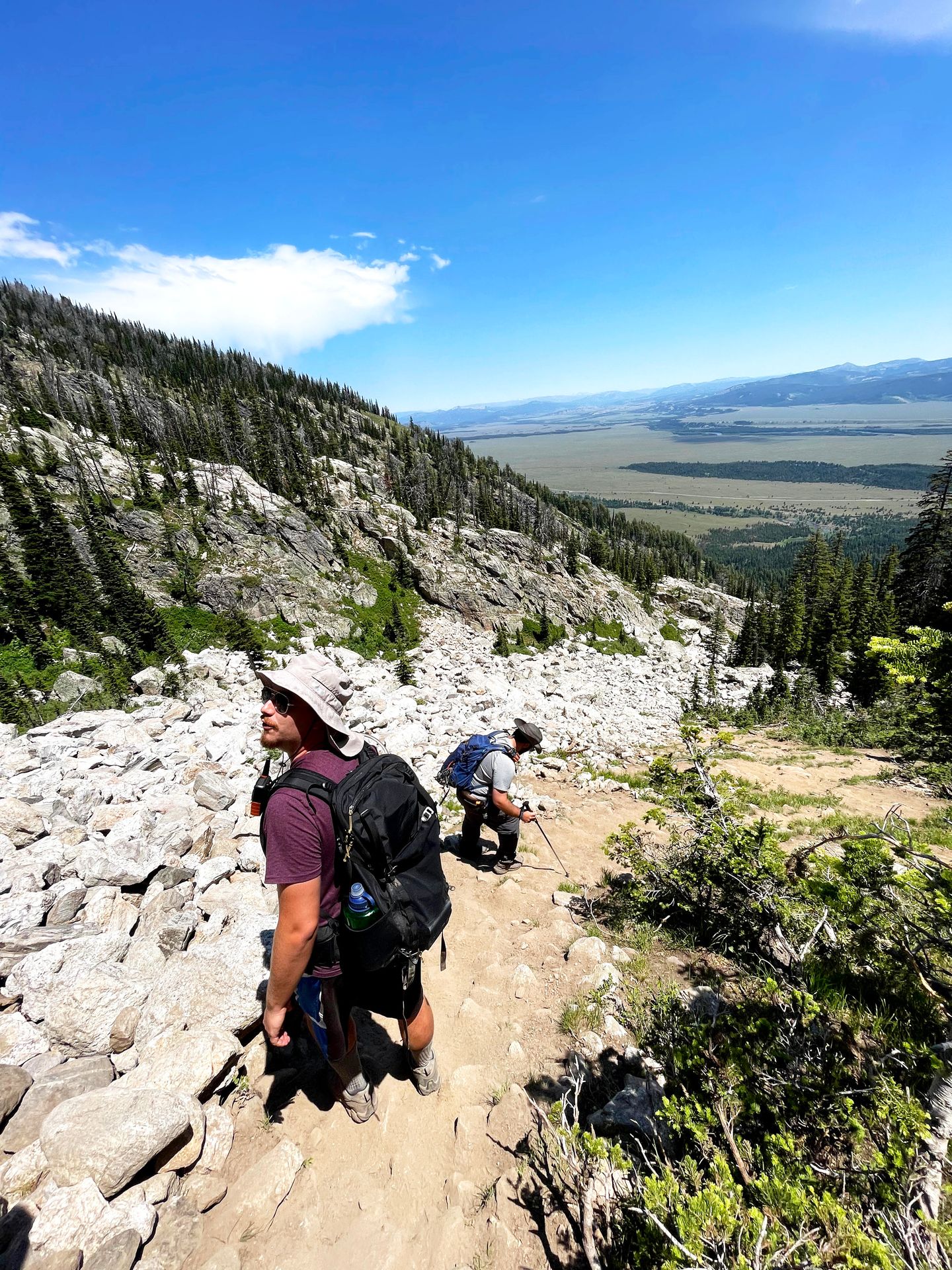 Two people hiking down the steep portion of the hike to Delta Lake.