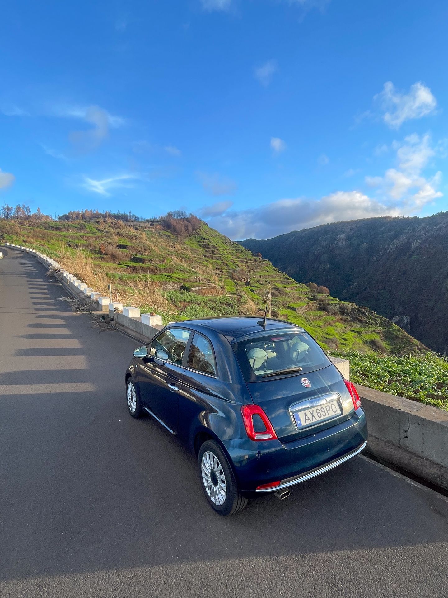 A tiny rental car parked on a street in Madeira.
