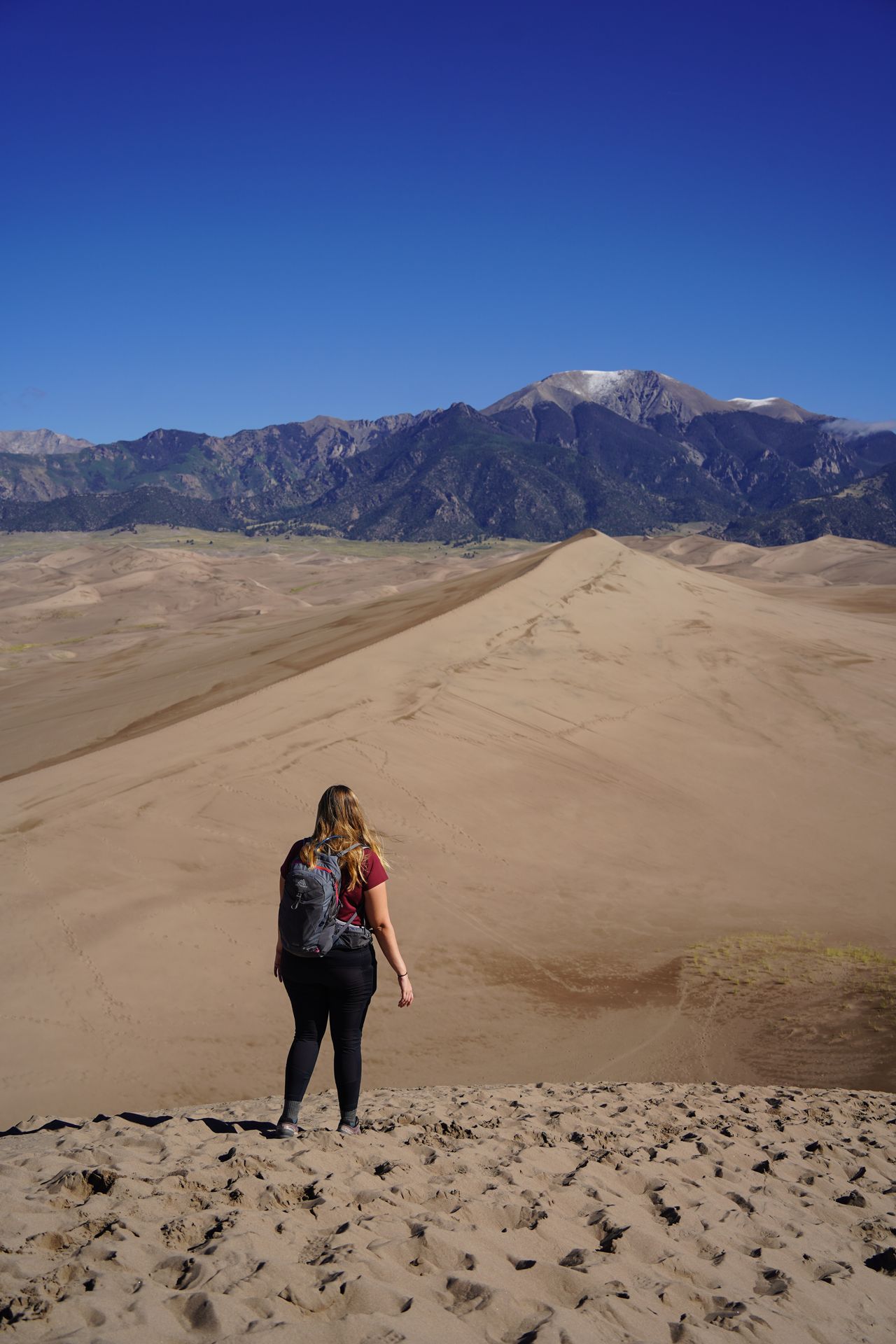 Lydia looking out at sand dunes and mountains