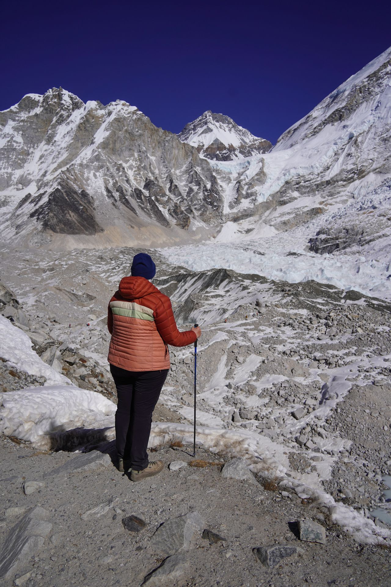 Lydia looking out at Everest Base Camp, which is surrounded by snow capped mountains and a glacier