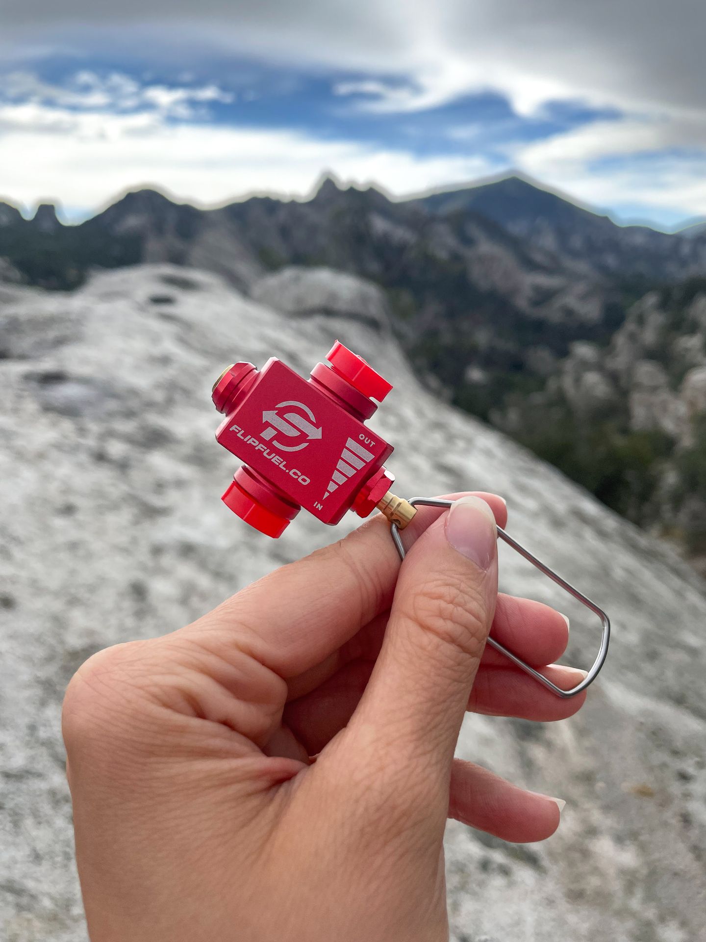Holding up the Flip Fuel, a small, red device.