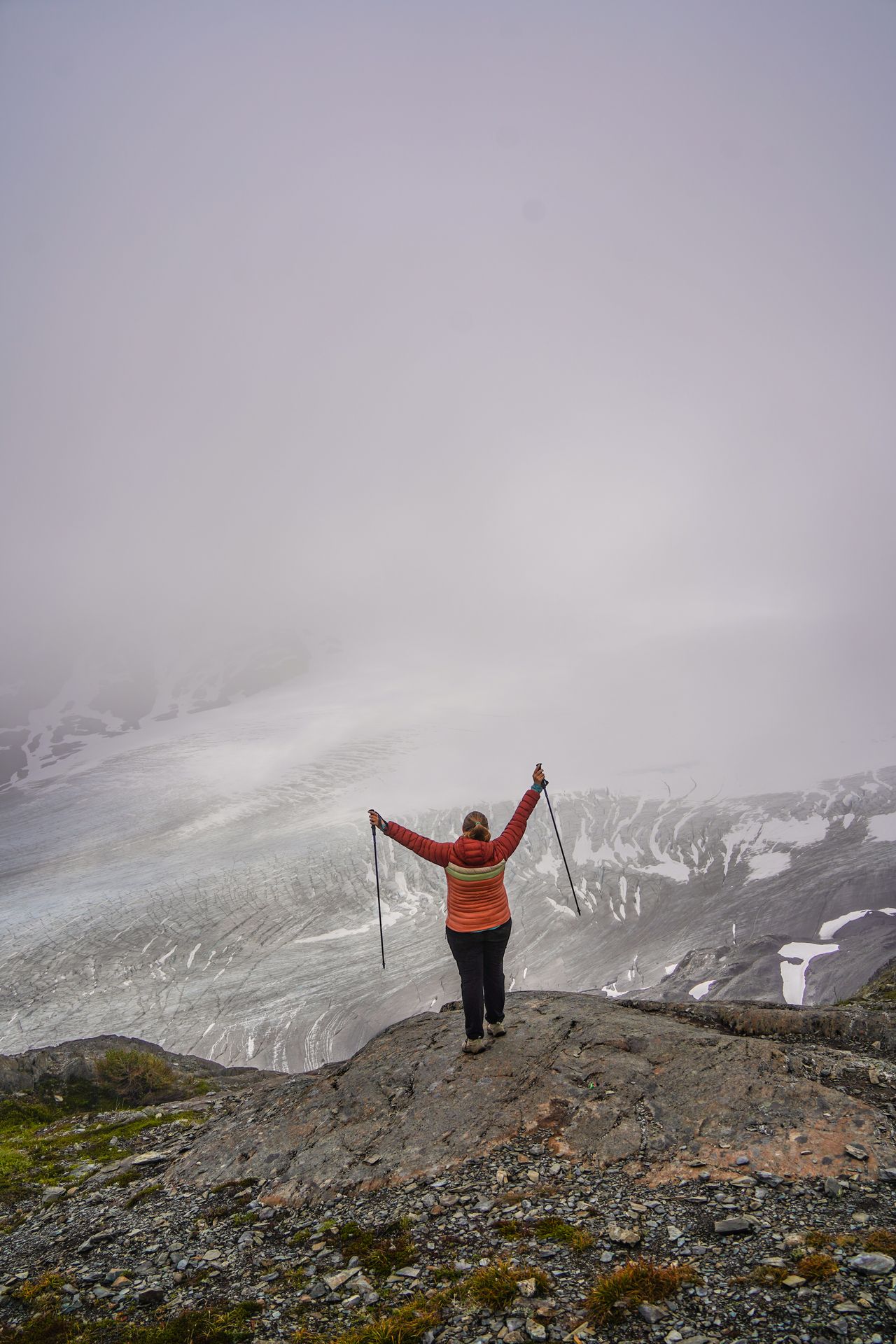 Lydia looking out at the Harding Icefield, which is mostly obscured by fog.
