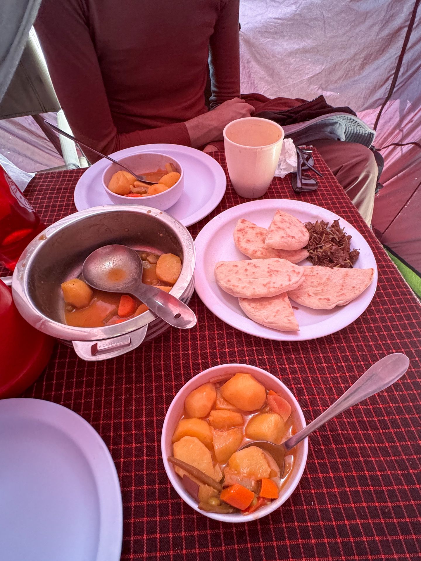 A table with a potato soup, bread and more food during the Kilimanjaro trek