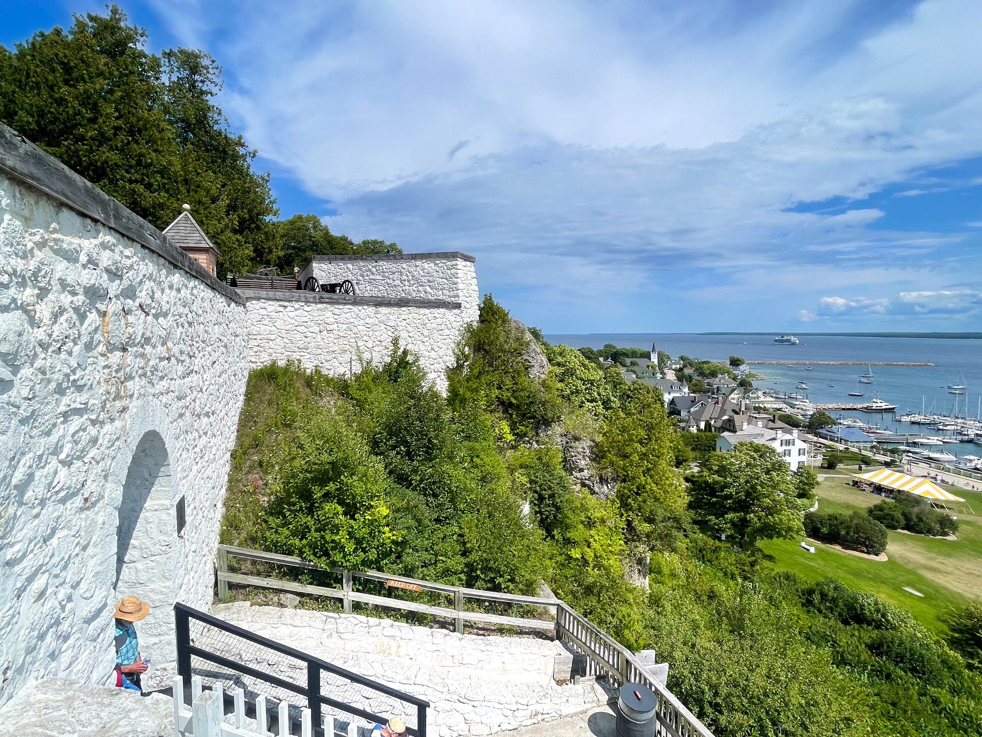 A white fort up on a hill overlooking Downtown Mackinac.