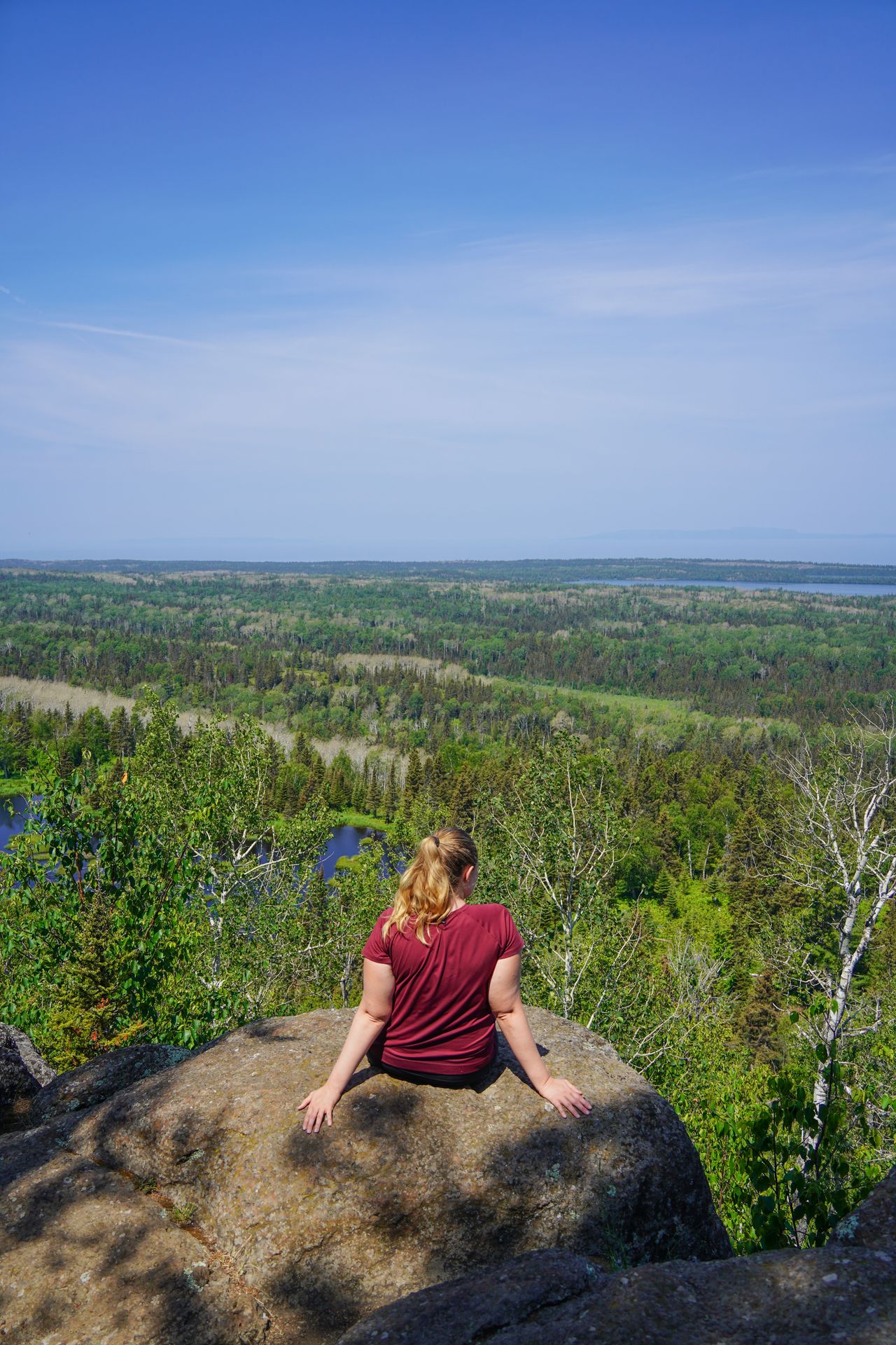 Lydia sitting on a rock and admiring the views from Mount Franklin