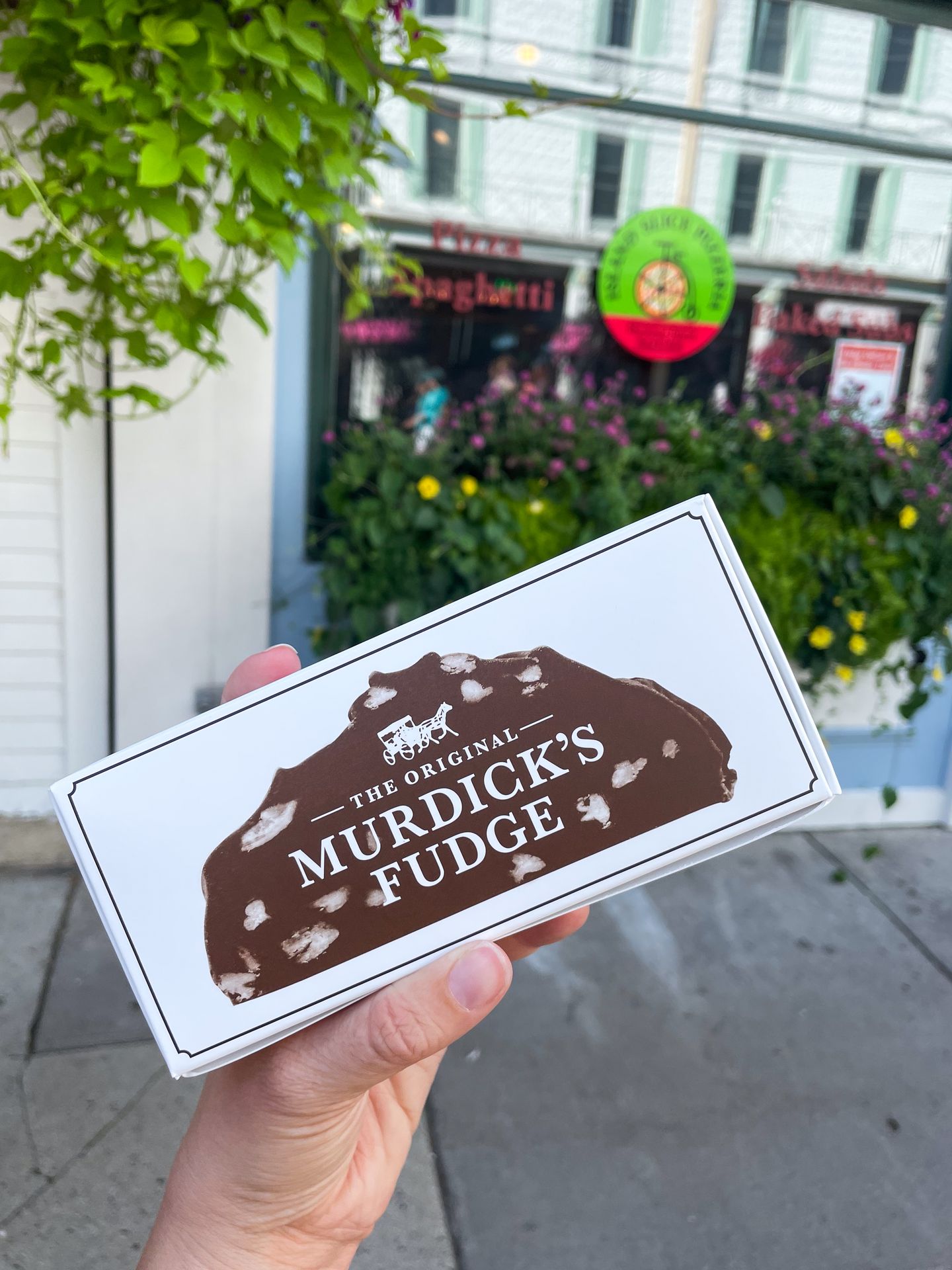 Holding up a box of fudge from Original Murick's Fudge.