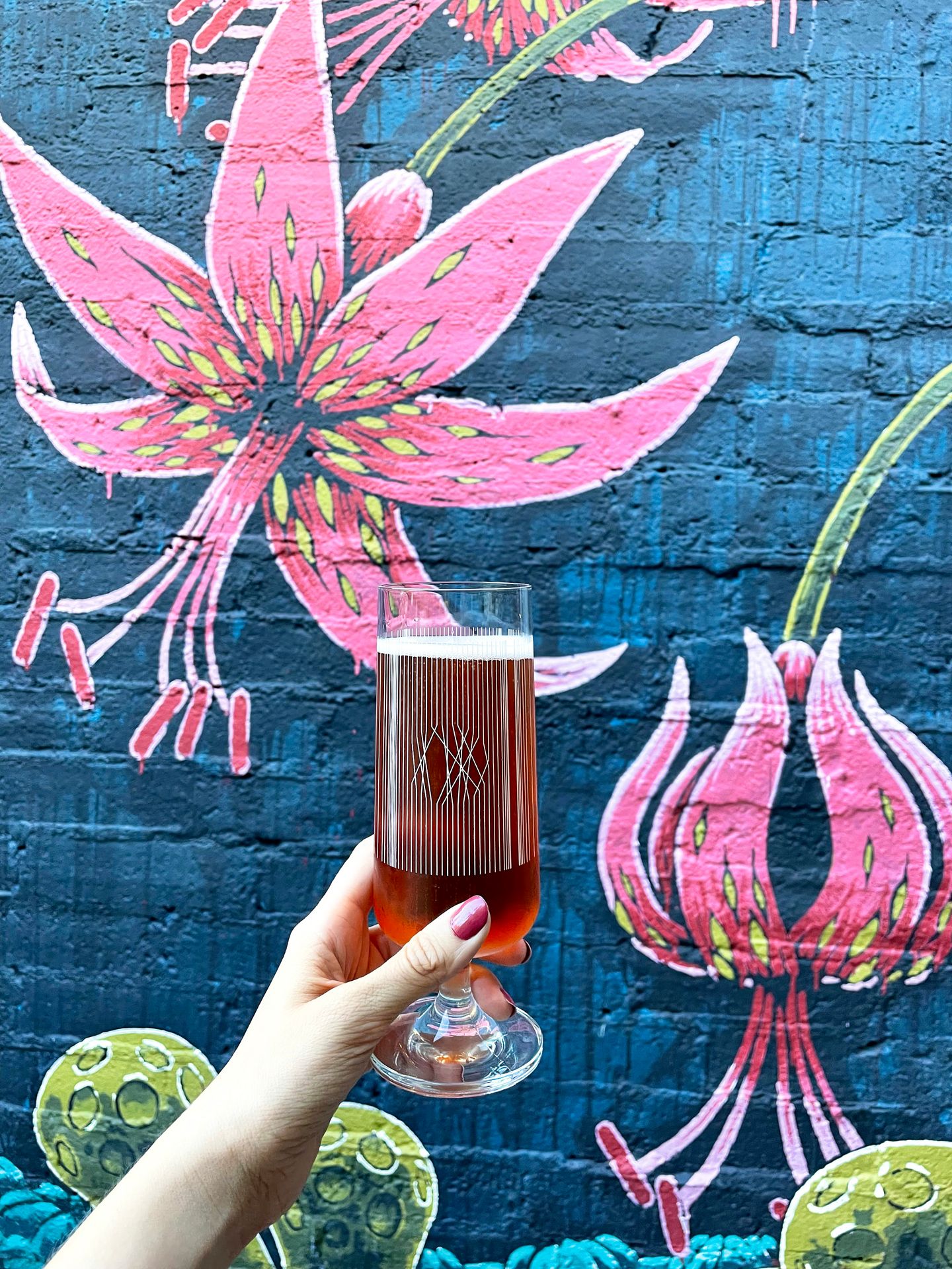 Holding up a beer in a tall glass at Wicked Weed Funkatorium